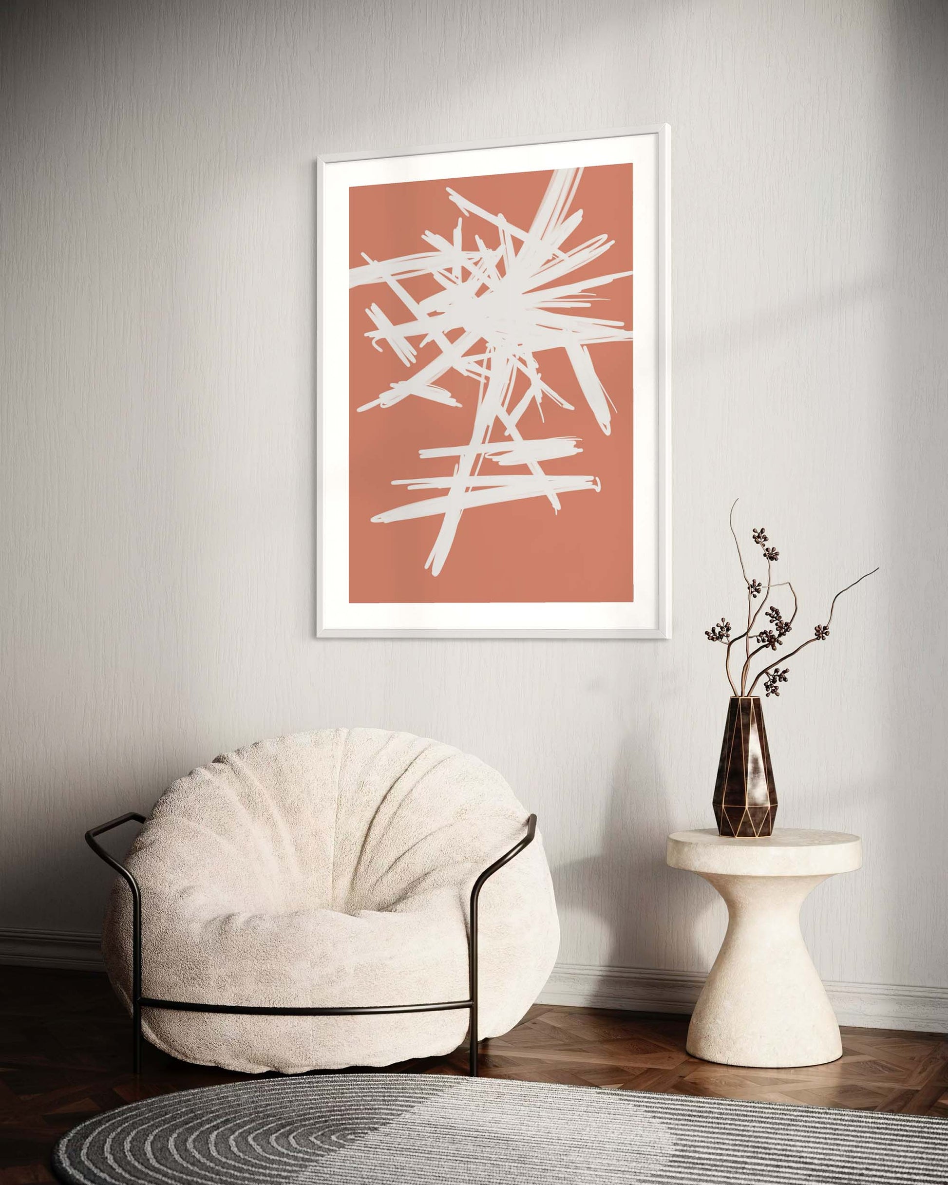 Abstract art print on a wall above a chair in a room.