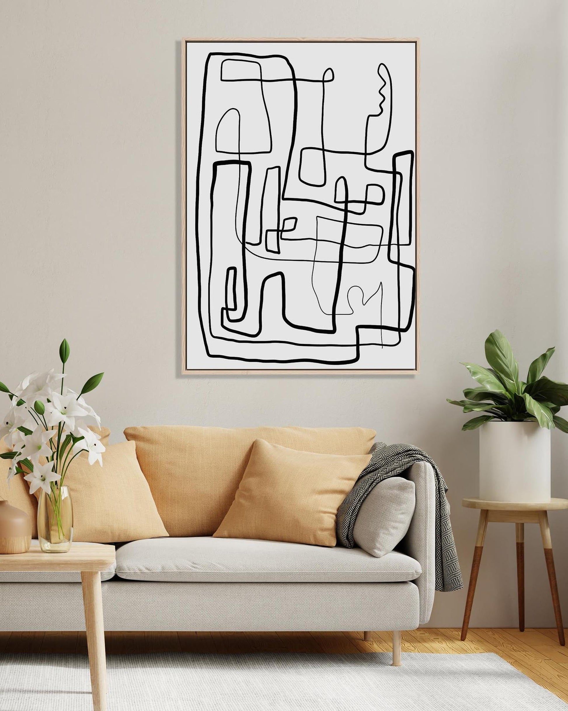 Abstract line art on a wall above a beige sofa in a living room.
