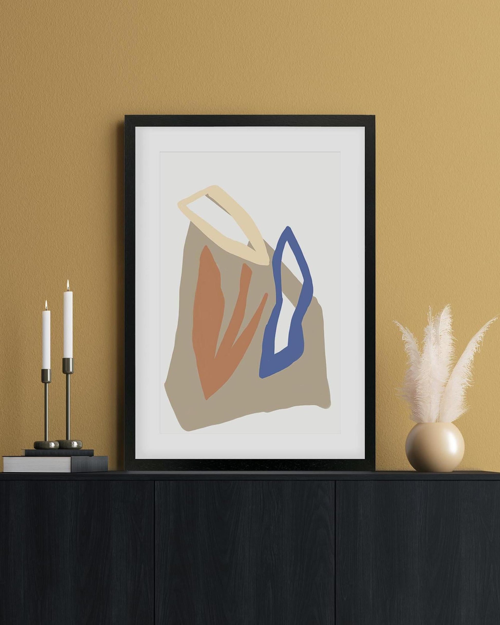 Framed abstract art print on a wall with decorative elements below.