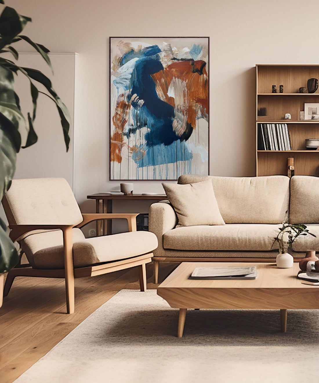 Modern living room with beige sofa, armchair, and abstract art on the wall.