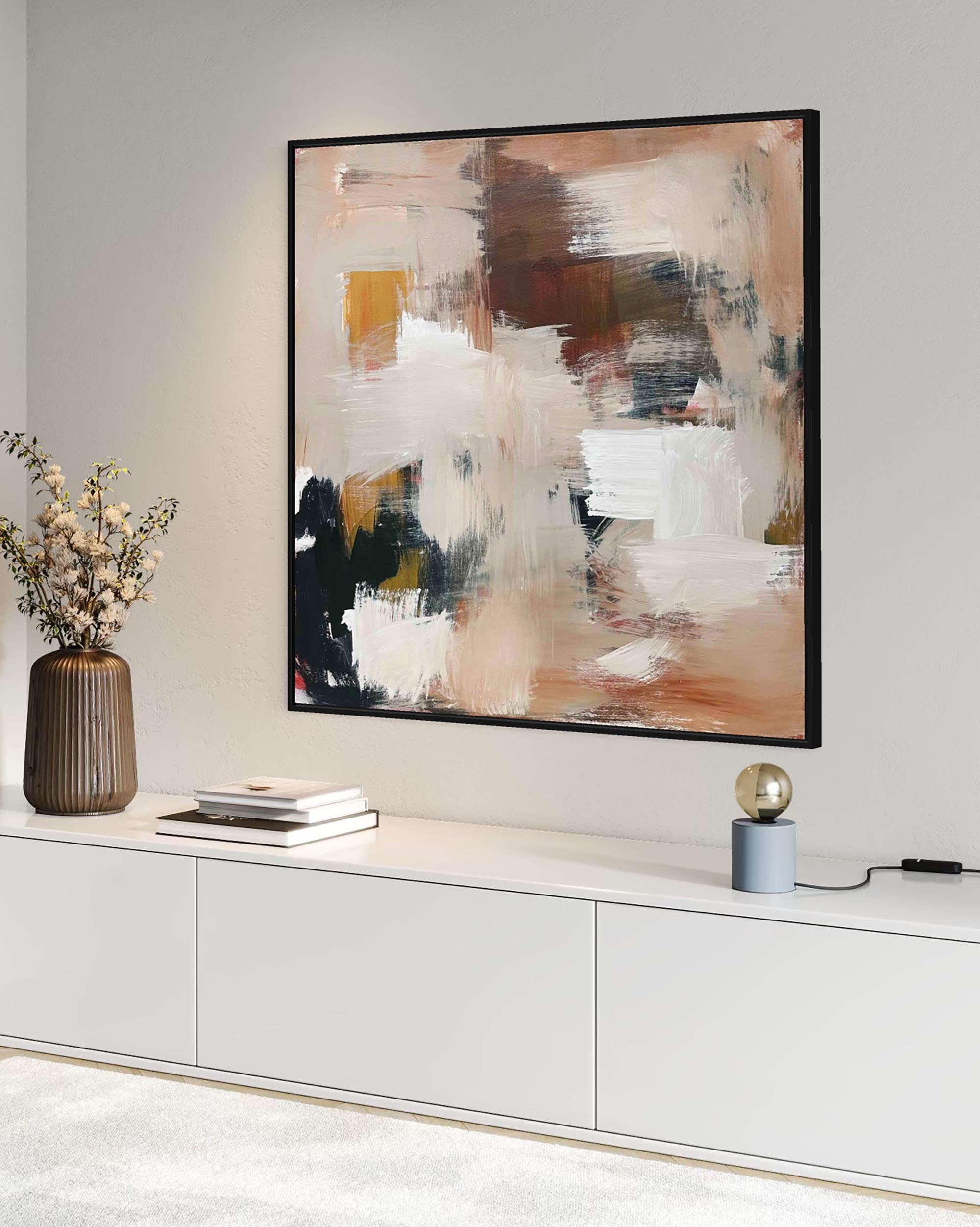 Abstract painting on a wall above a white cabinet with decorative items.