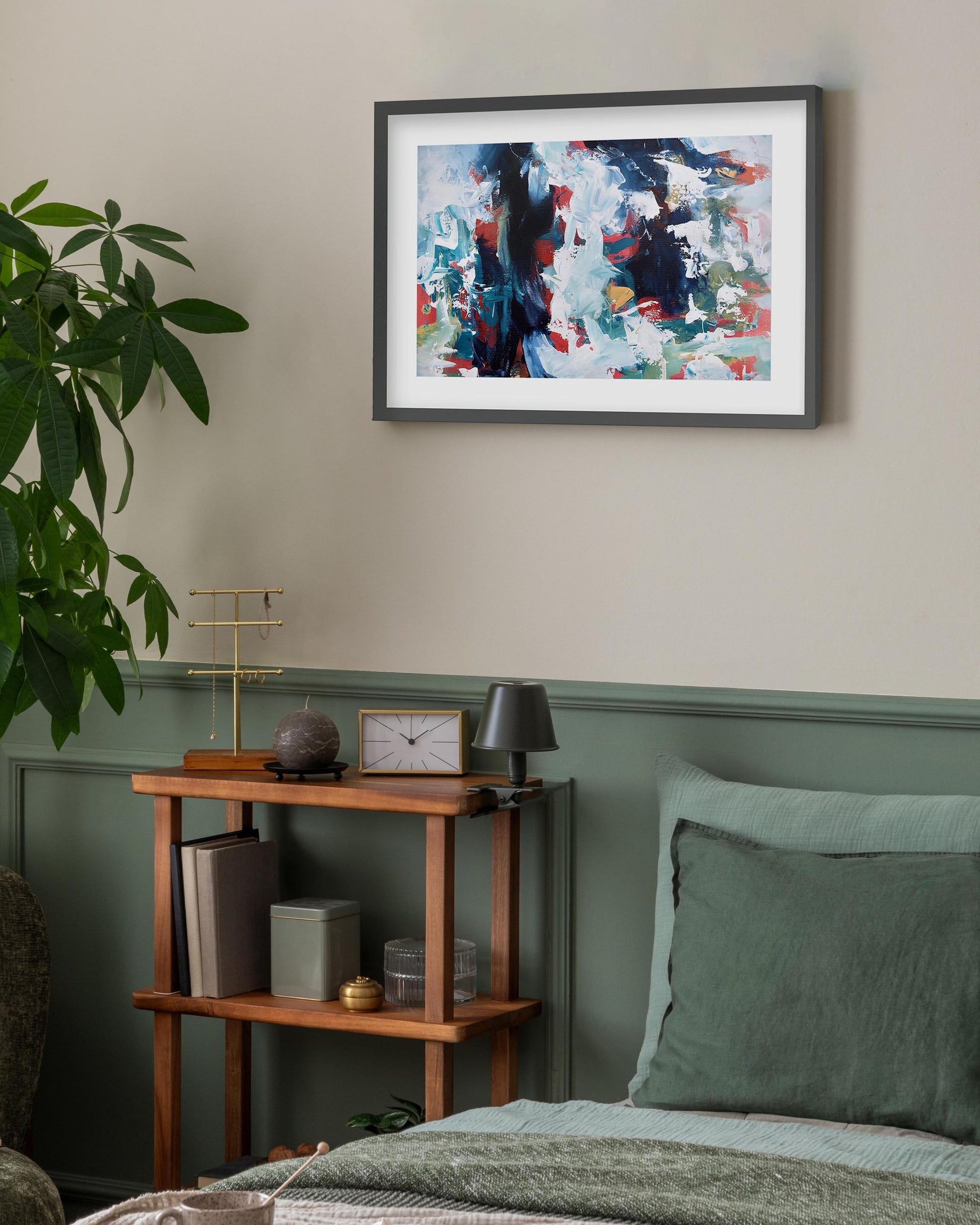 Living room with abstract art, plant, and wooden side table.