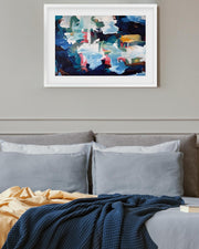 Abstract painting on a wall above a sofa with cushions and a blanket.