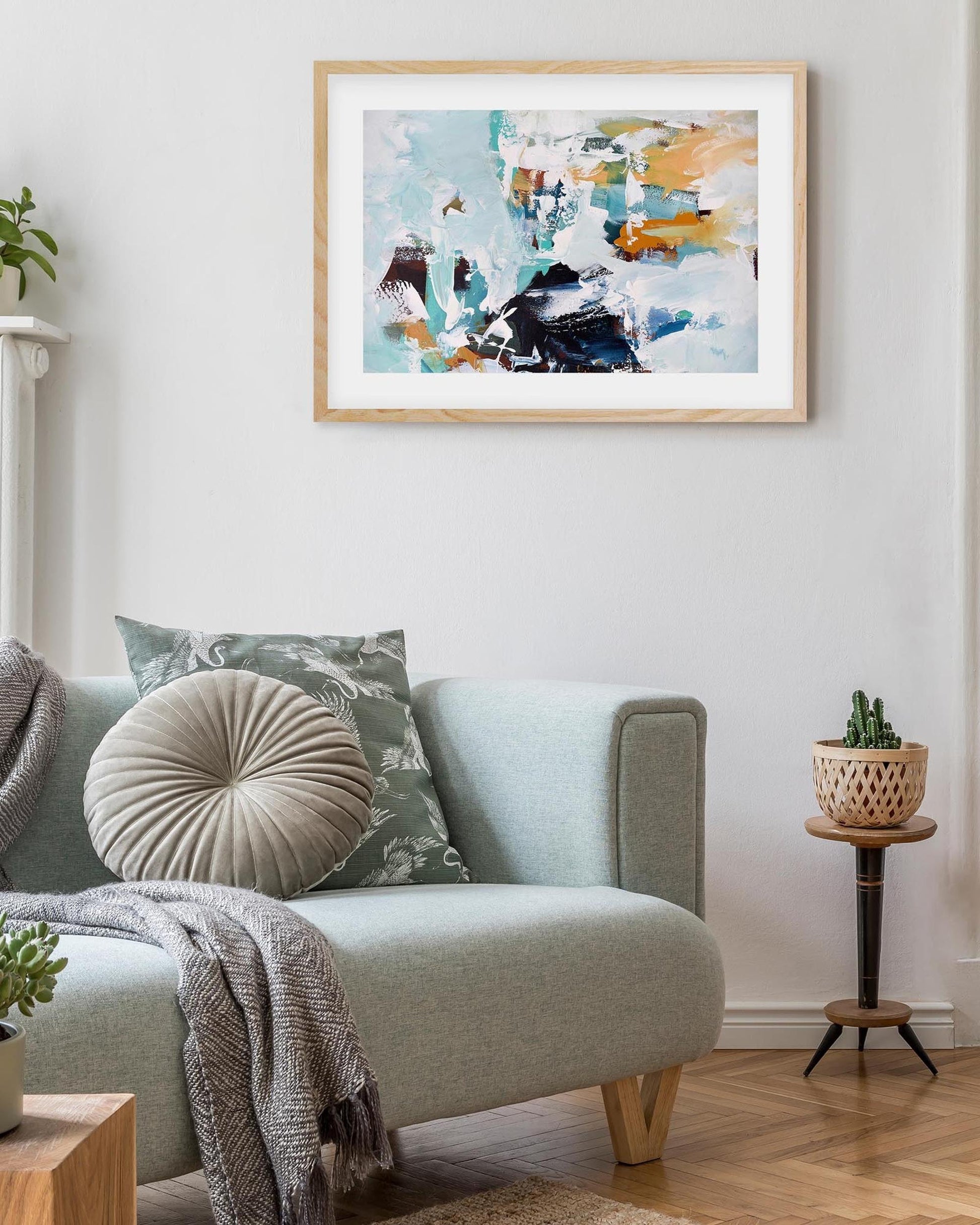 Living room with a light gray sofa, decorative pillows, and a colorful abstract painting on the wall.