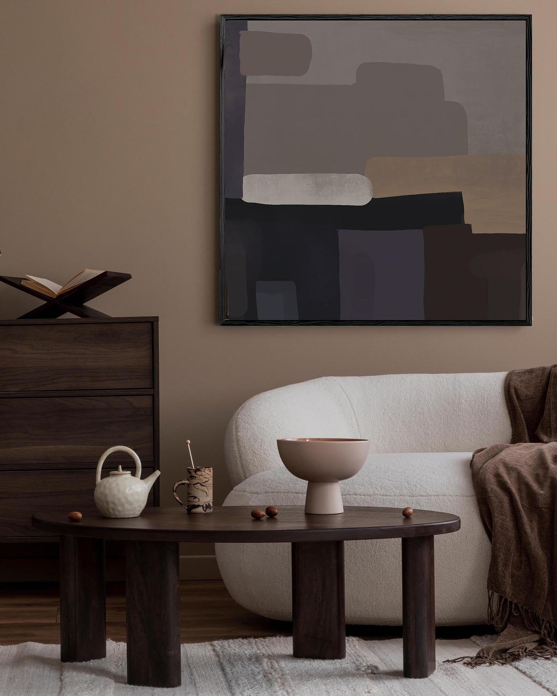 Modern living room with a white sofa, wooden coffee table, and abstract art on the wall.