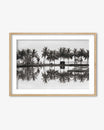 Framed black and white photograph of palm trees reflected in water on a white background