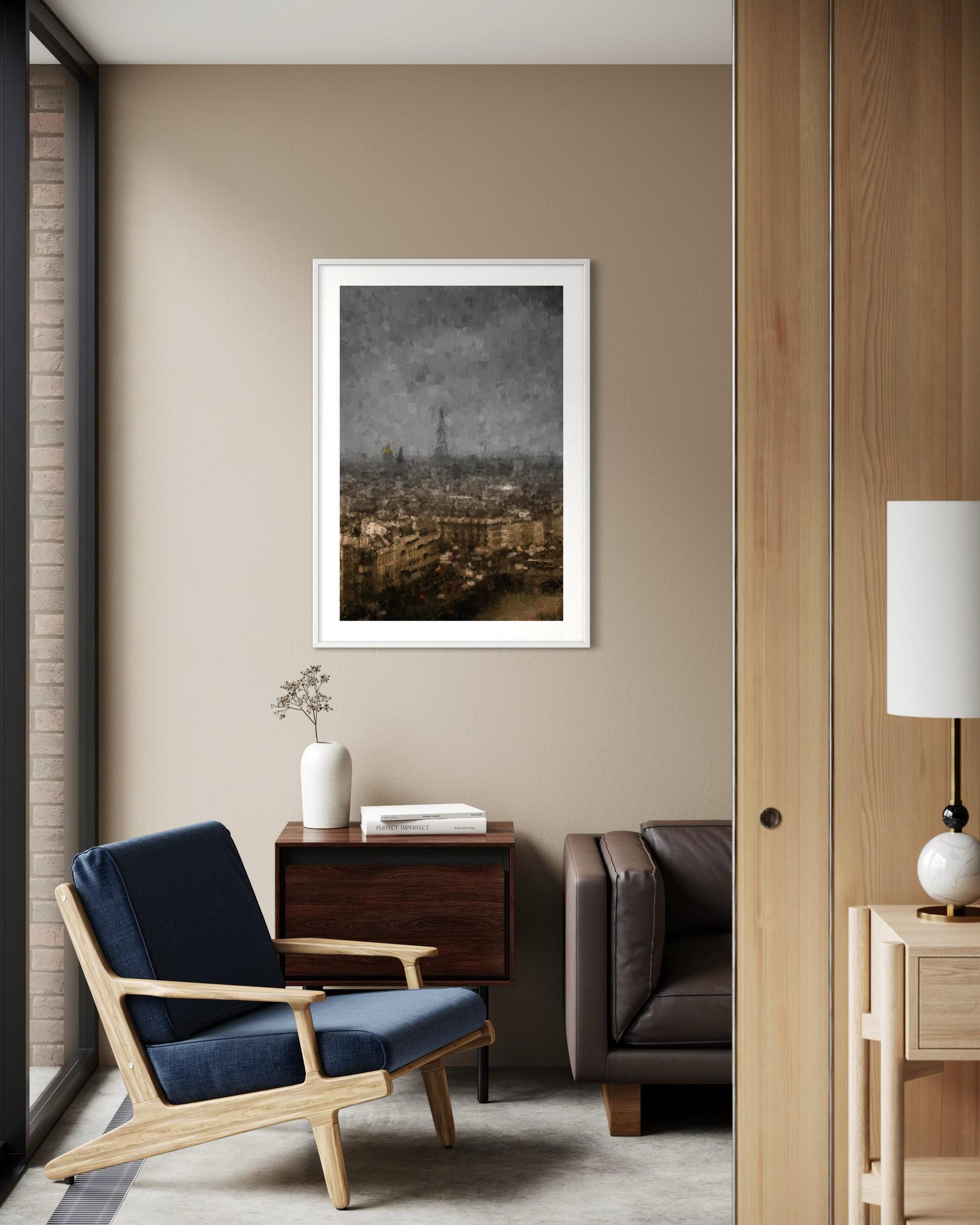 Modern living room with a blue armchair, wooden side table, and framed artwork on the wall.