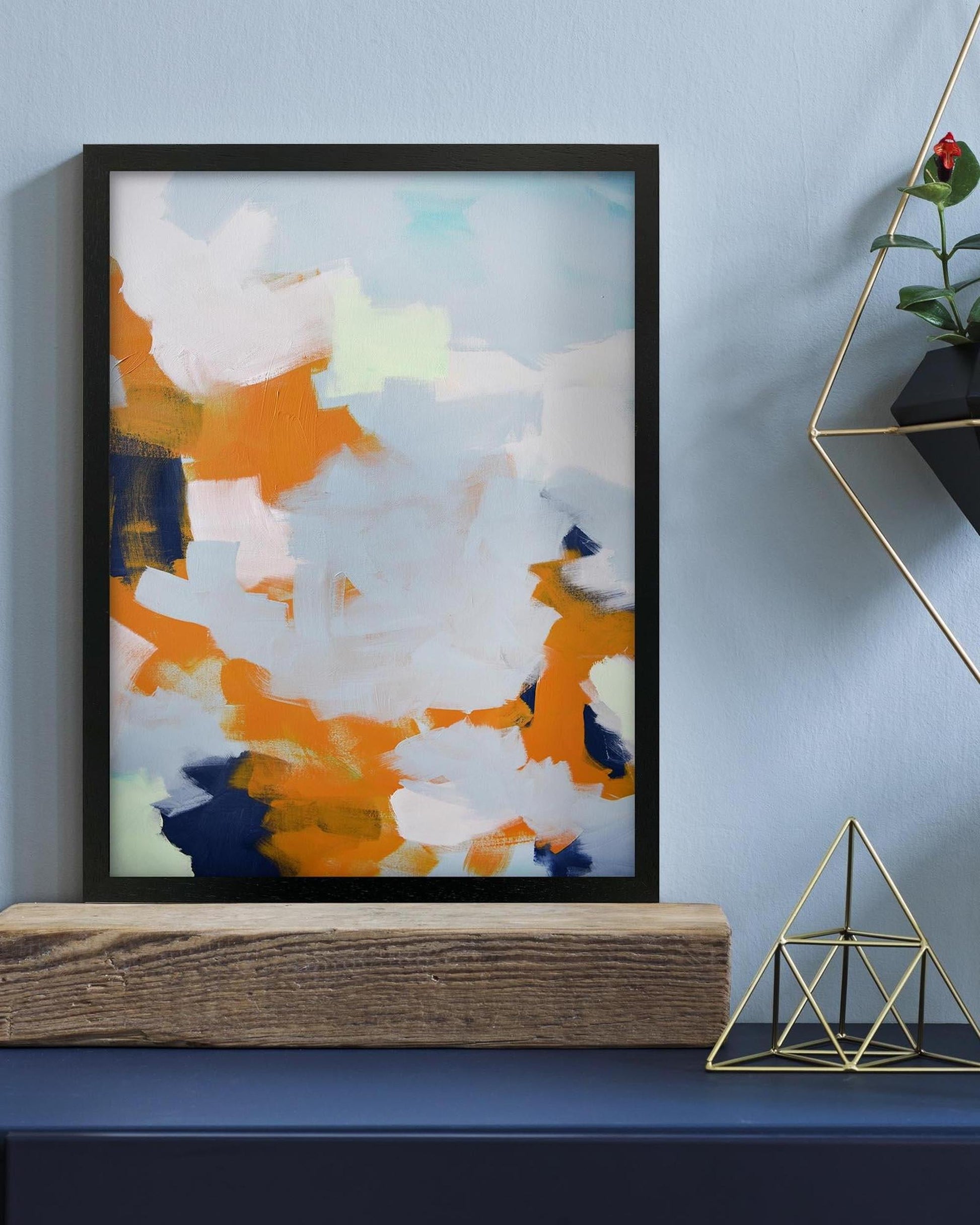 Framed abstract art piece on a wall with decorative elements.