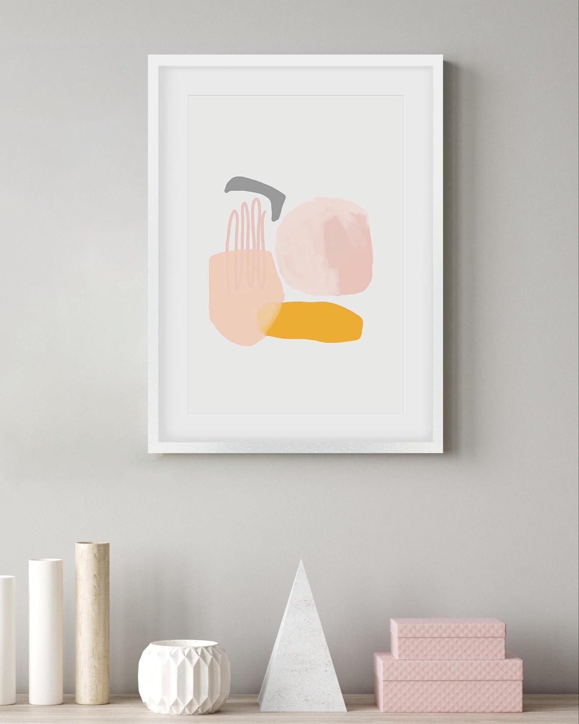 Abstract art print with colorful shapes on a gray wall, with decorative items below.