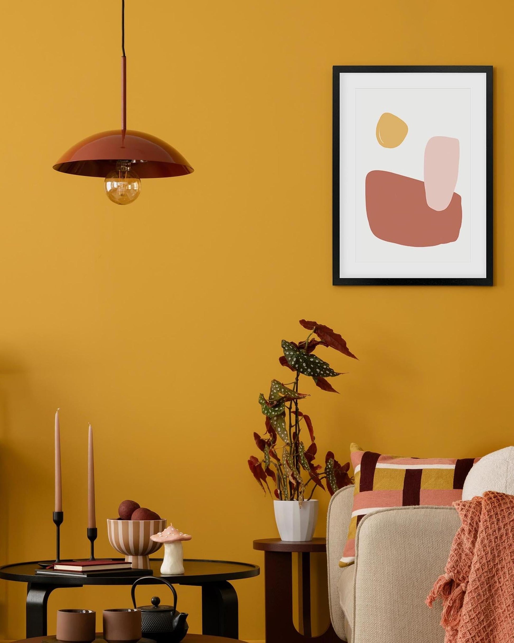 Living room with abstract art on a yellow wall, modern decor, and a cozy atmosphere.