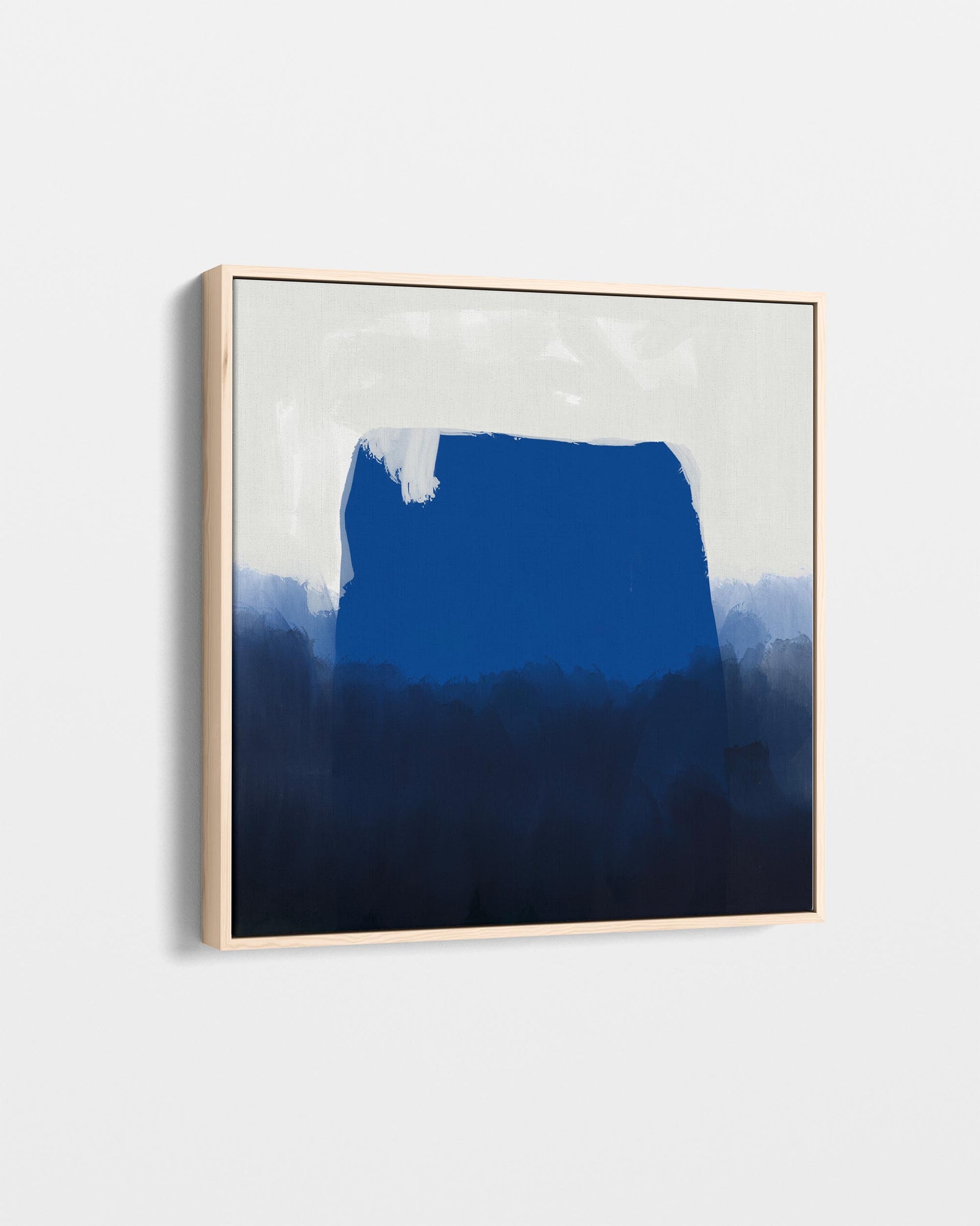 Abstract art piece with a gradient of blue tones in a gold frame on a light gray background