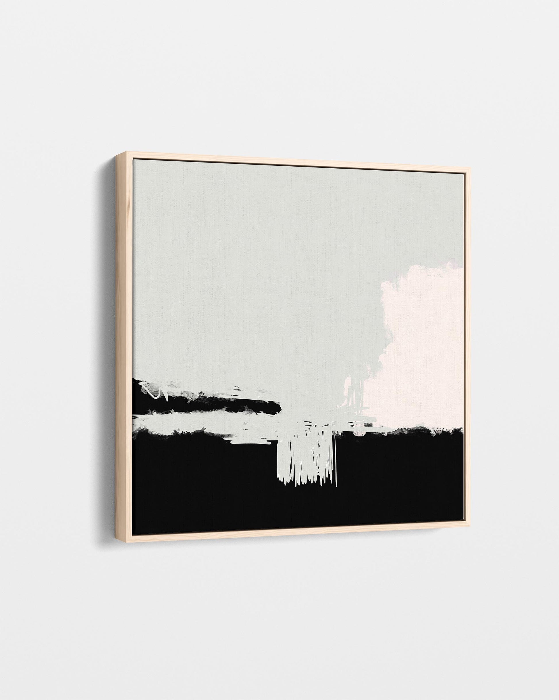 Abstract art print with black, white, and gray brush strokes in a gold frame on a light gray background
