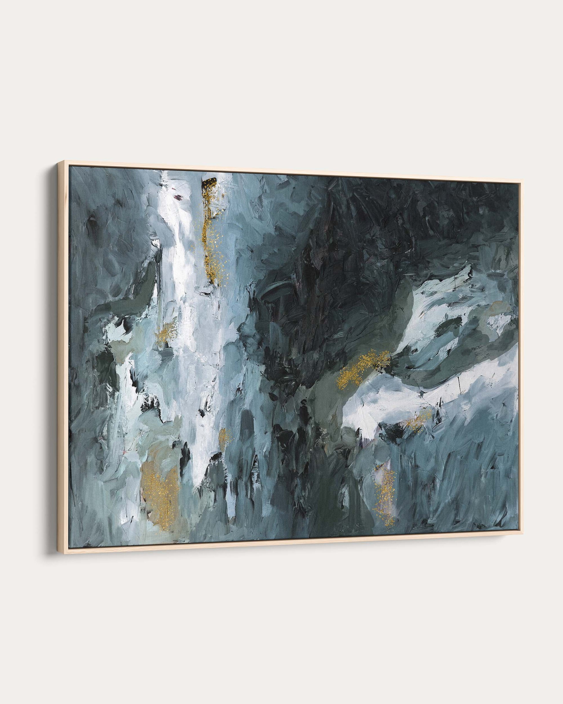 Abstract painting with blue, gray, and gold tones on a white wall