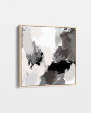 Abstract art piece with black and white brush strokes in a gold frame on a light gray background