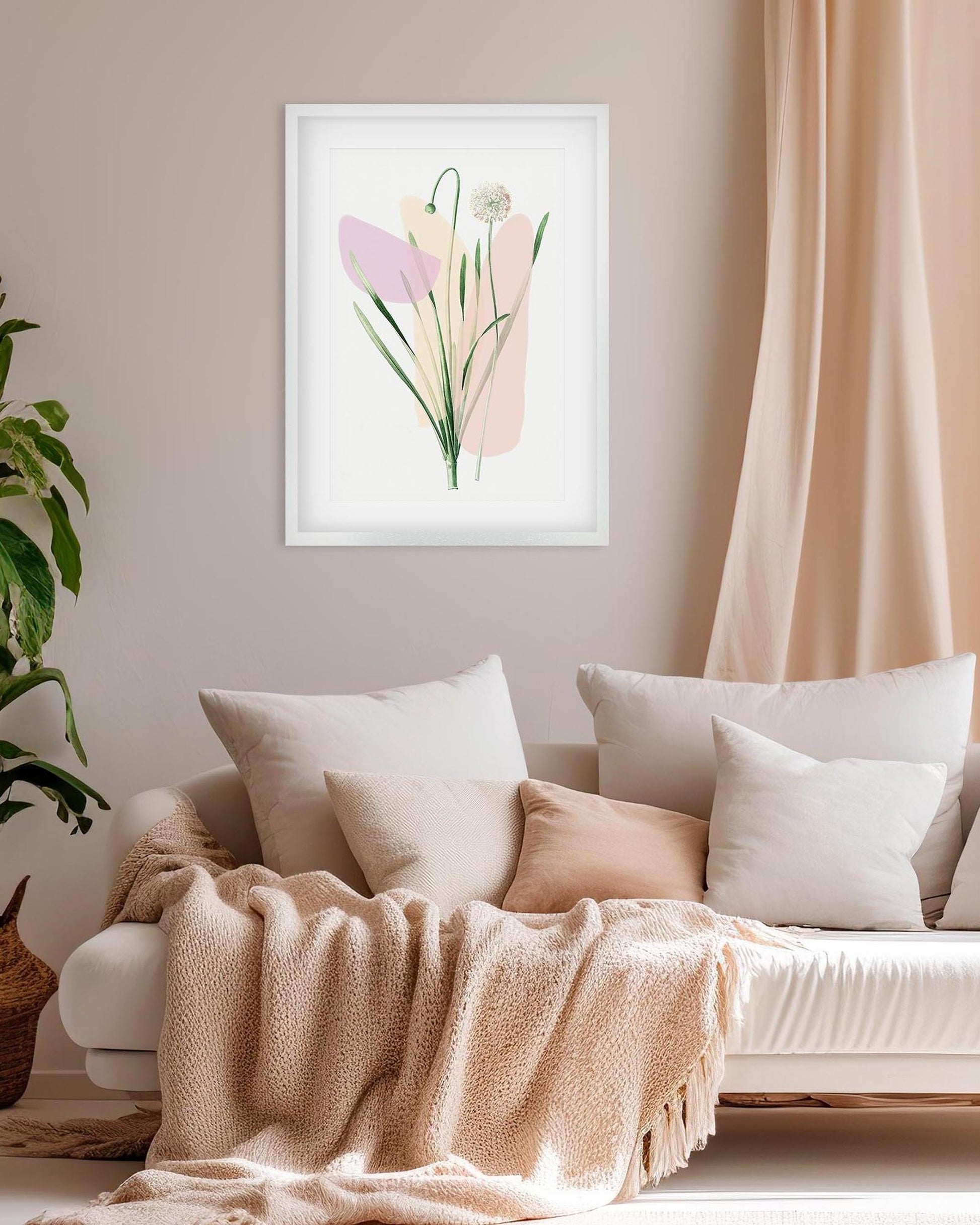 Framed floral artwork above a sofa with pillows and a blanket in a living room setting.