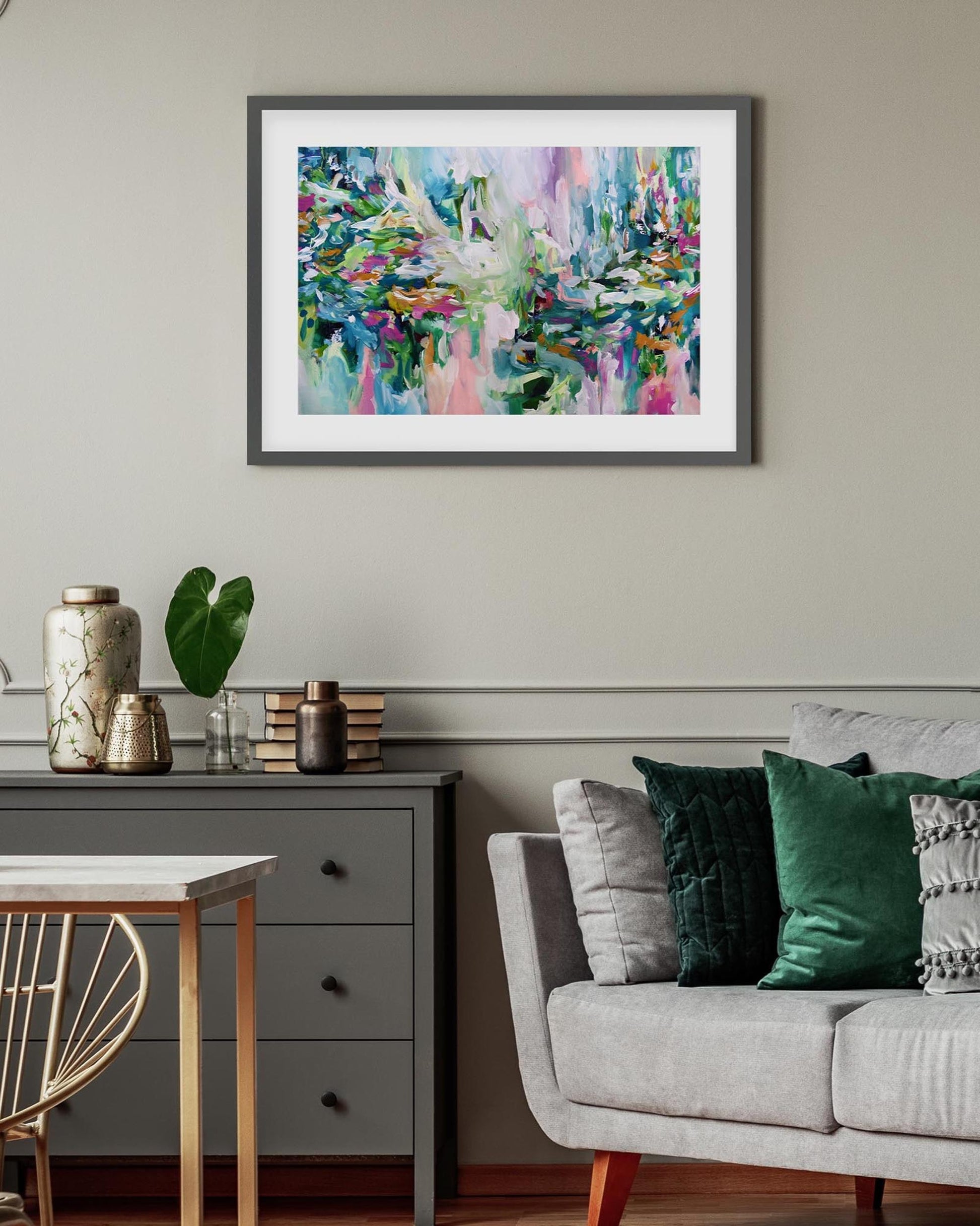 Living room with a colorful abstract painting on the wall, gray sofa, and wooden side table.