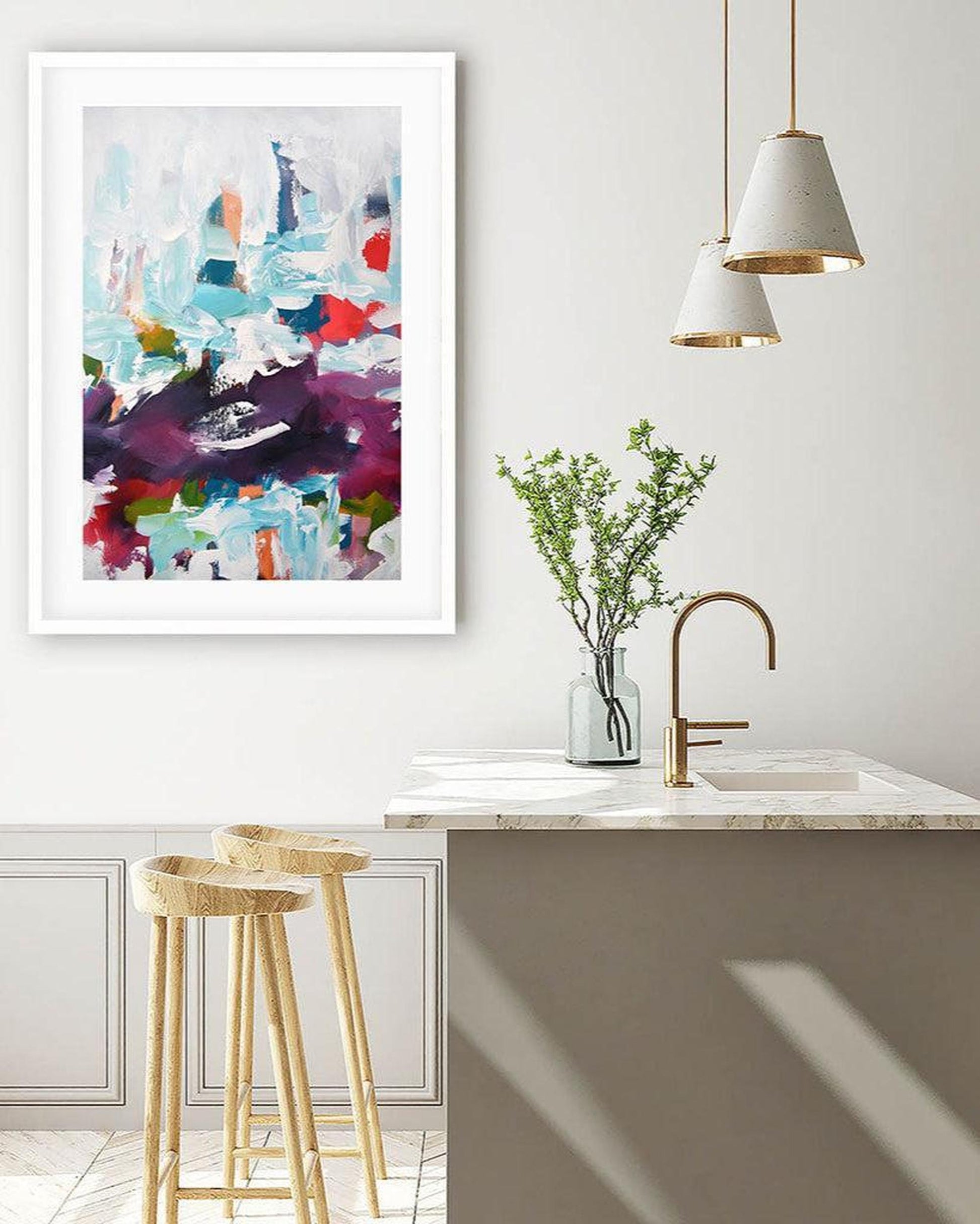 Modern kitchen with abstract art on the wall, stools, and a vase with greenery.