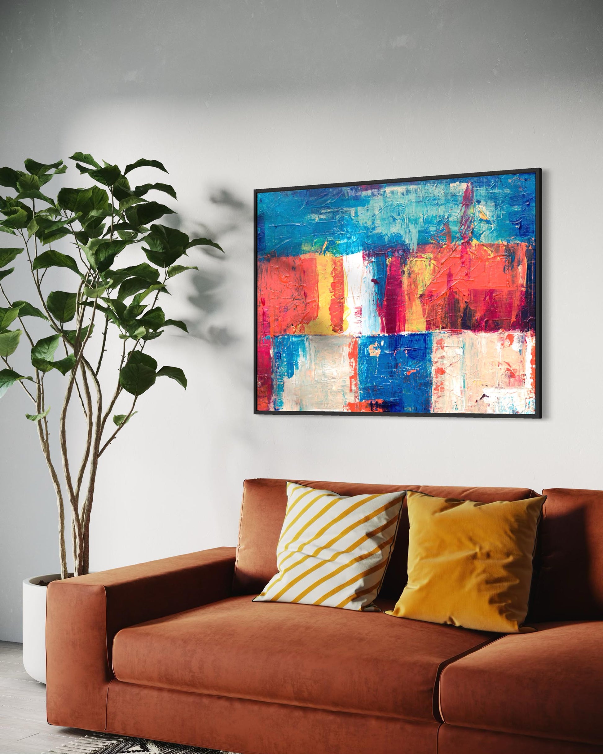 Colorful abstract painting on a wall above a brown sofa with decorative pillows.