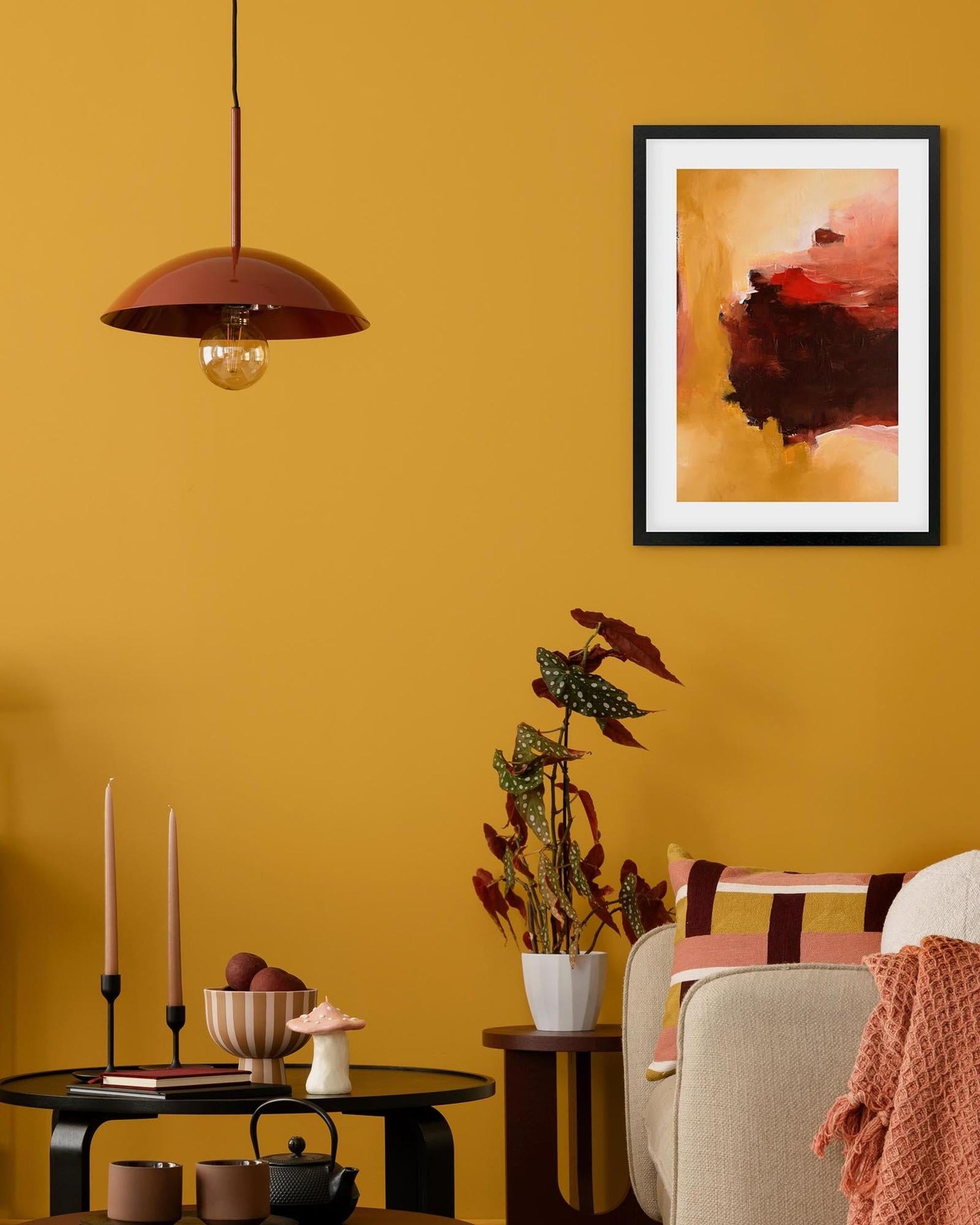 Living room with yellow walls, a framed abstract painting, and decorative items.