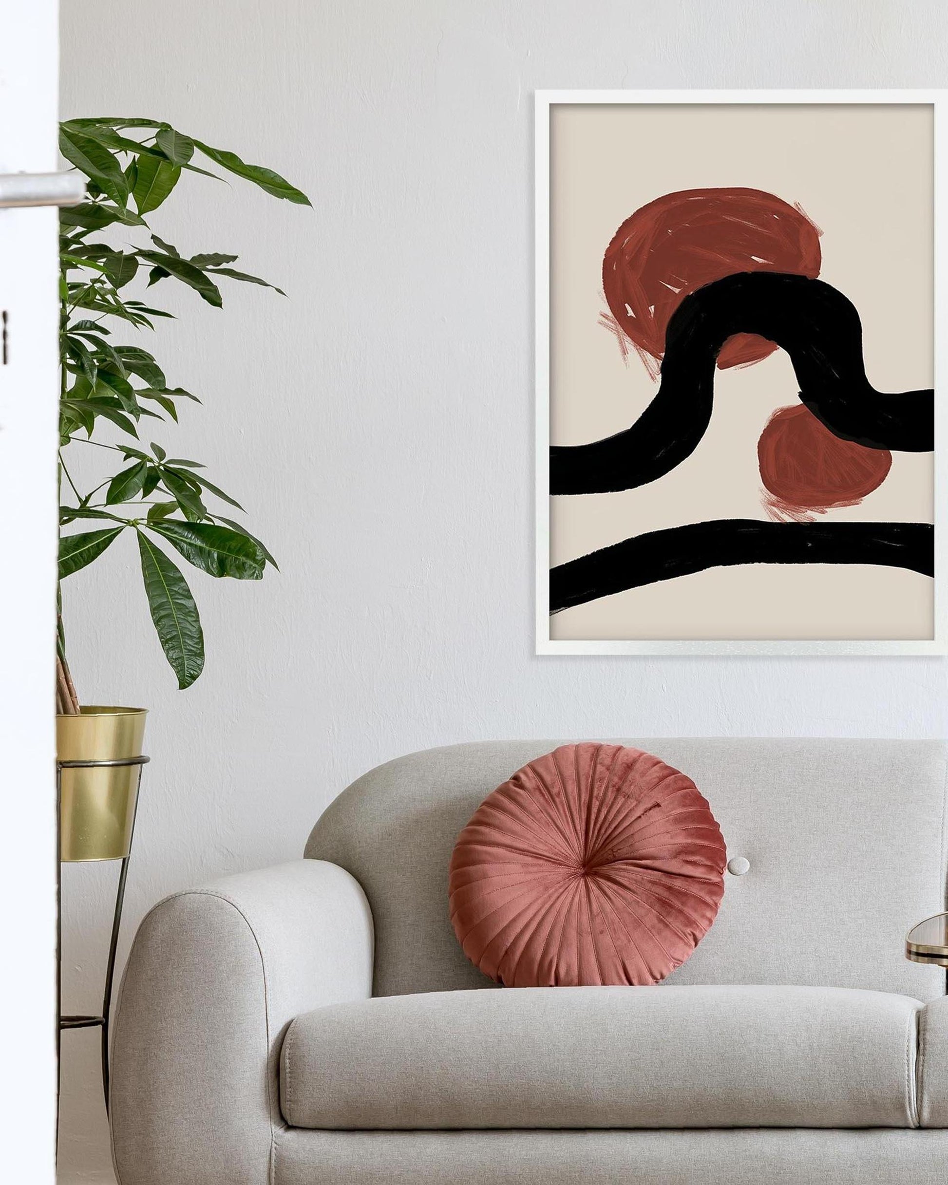 Sofa with a pink pillow and abstract art on the wall