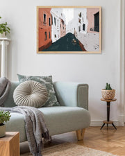Living room with a light blue sofa, decorative pillows, and a framed painting on the wall.