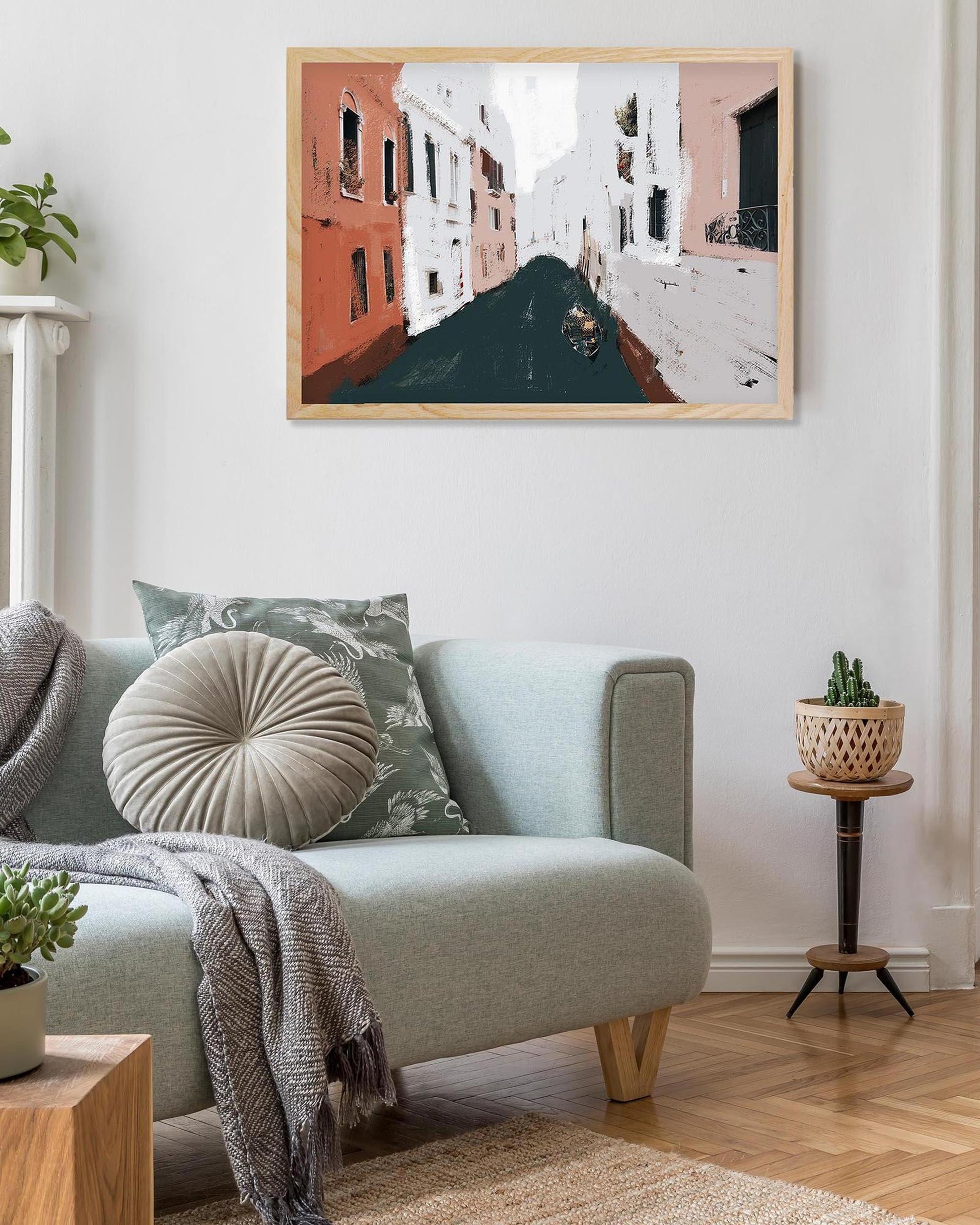 Living room with a light blue sofa, decorative pillows, and a framed painting on the wall.