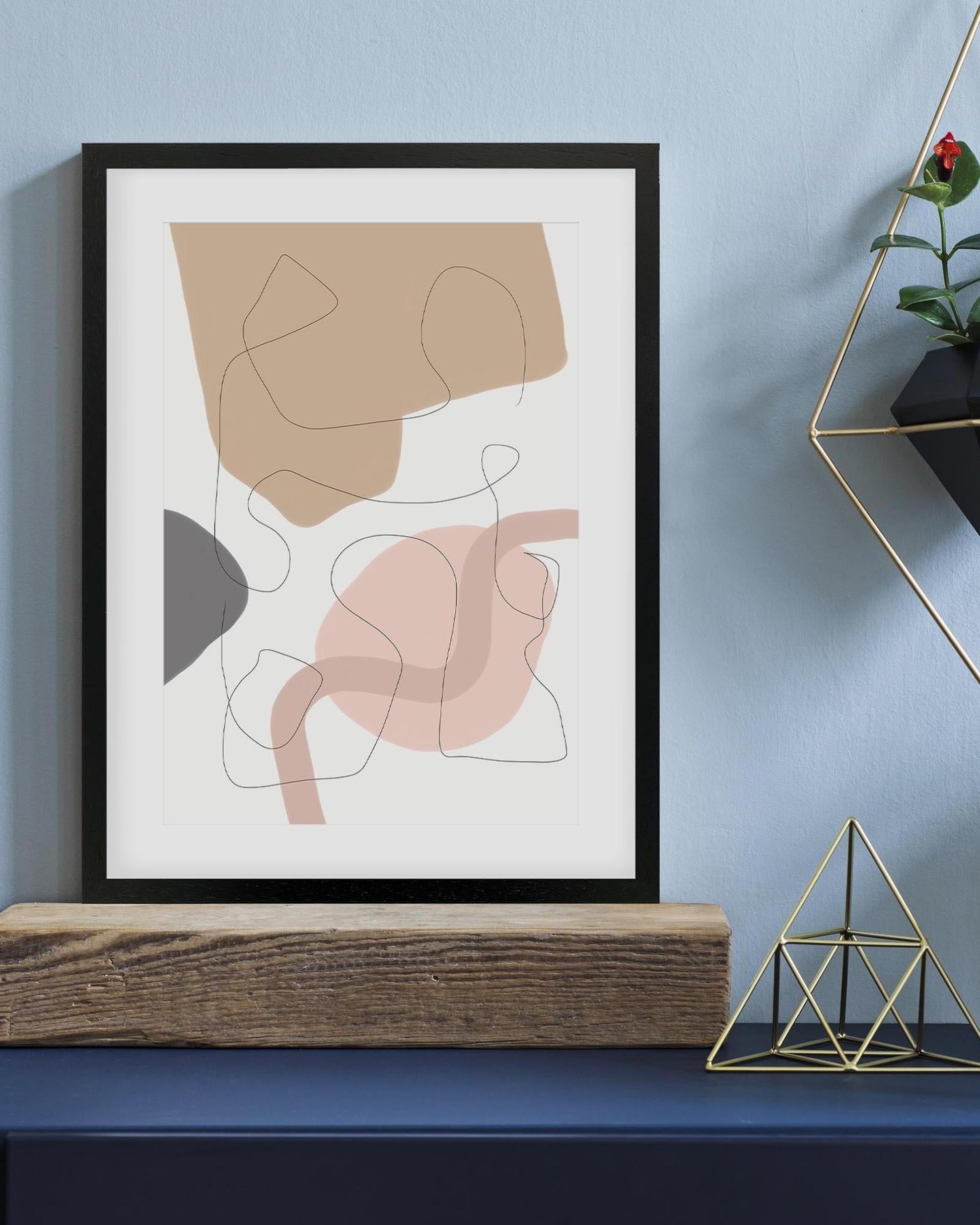 Framed abstract art piece on a wall with decorative elements below.