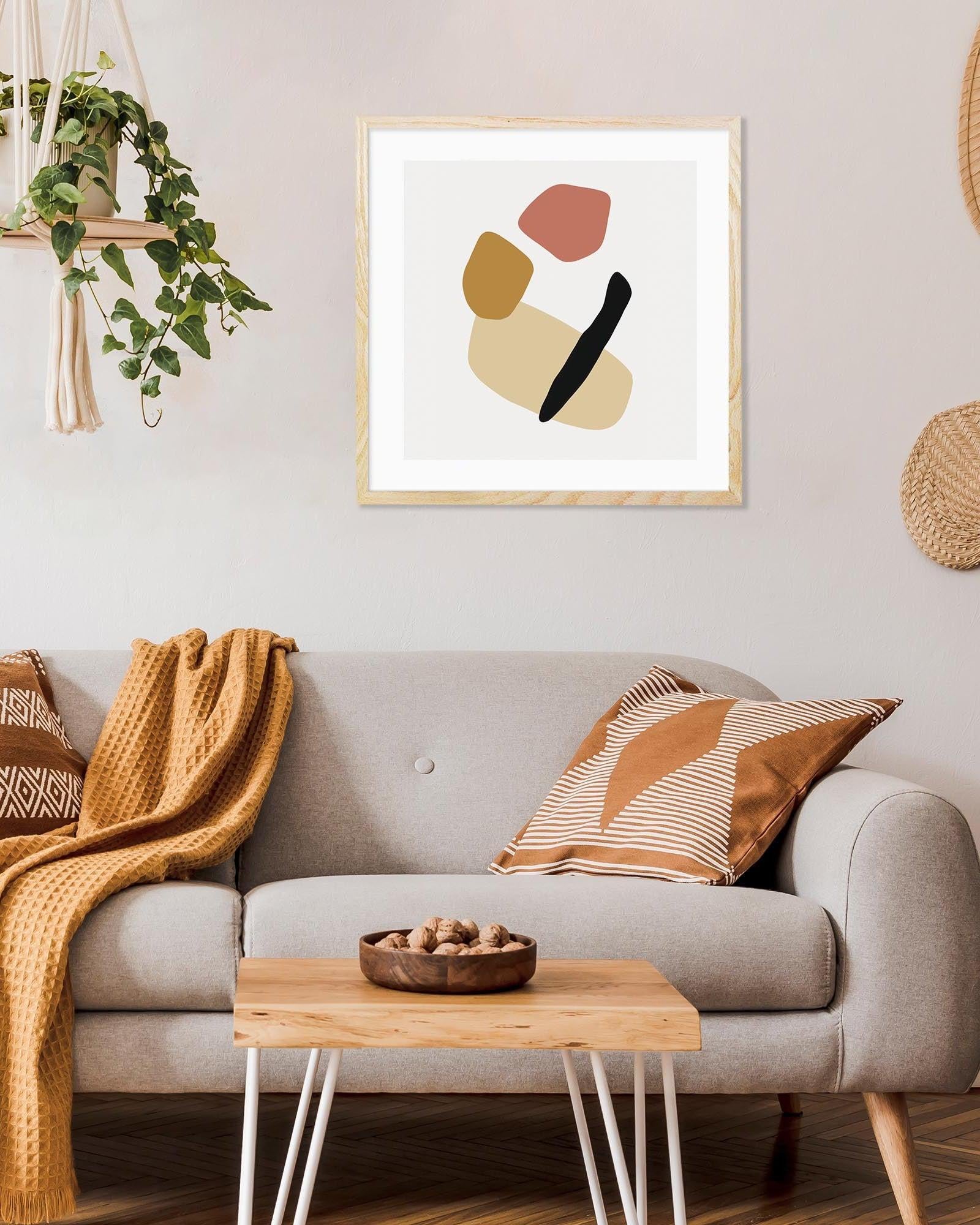 Living room with a gray sofa, wooden coffee table, and abstract art on the wall.