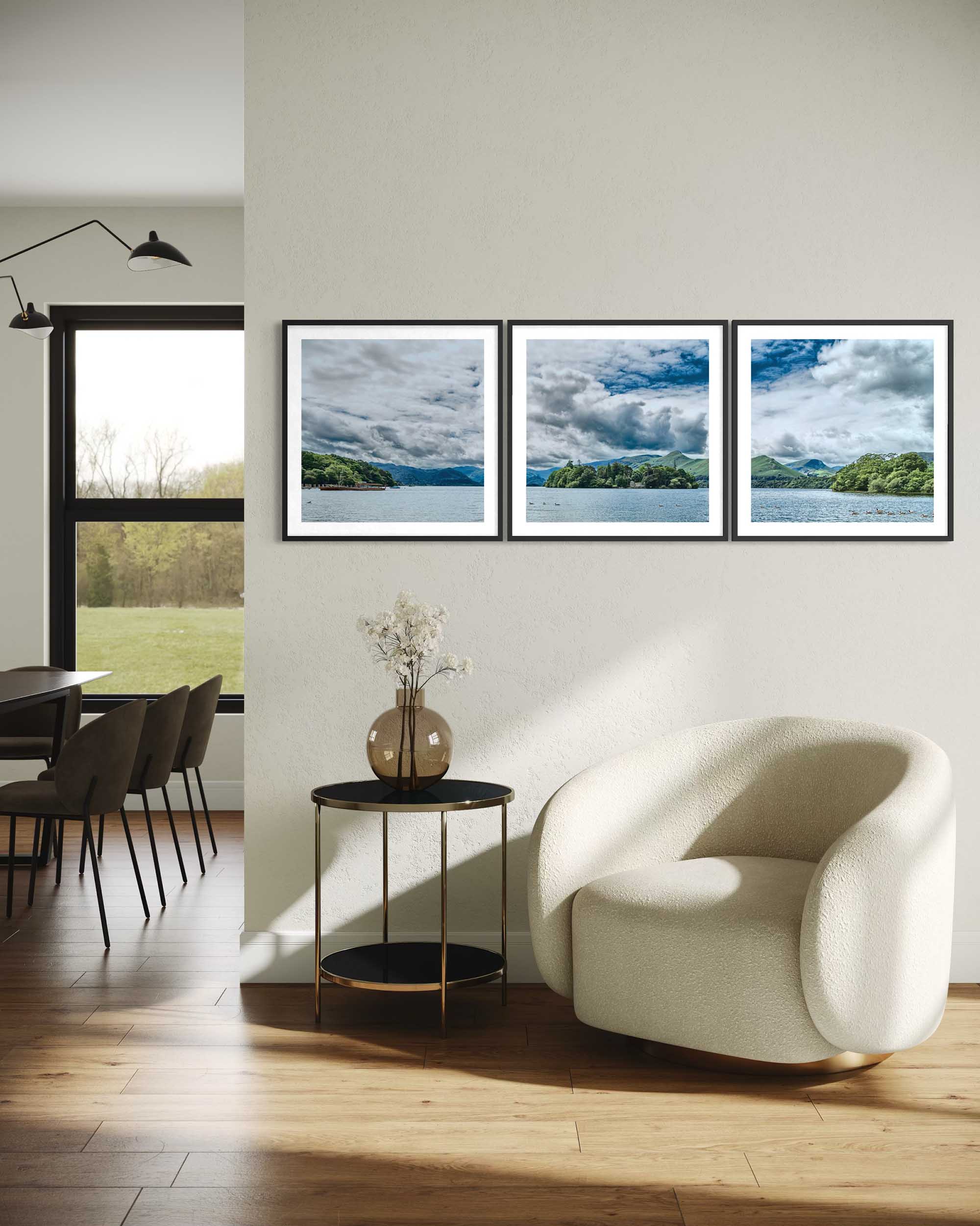 Modern living room with a white armchair, round table, and framed landscape pictures on the wall.