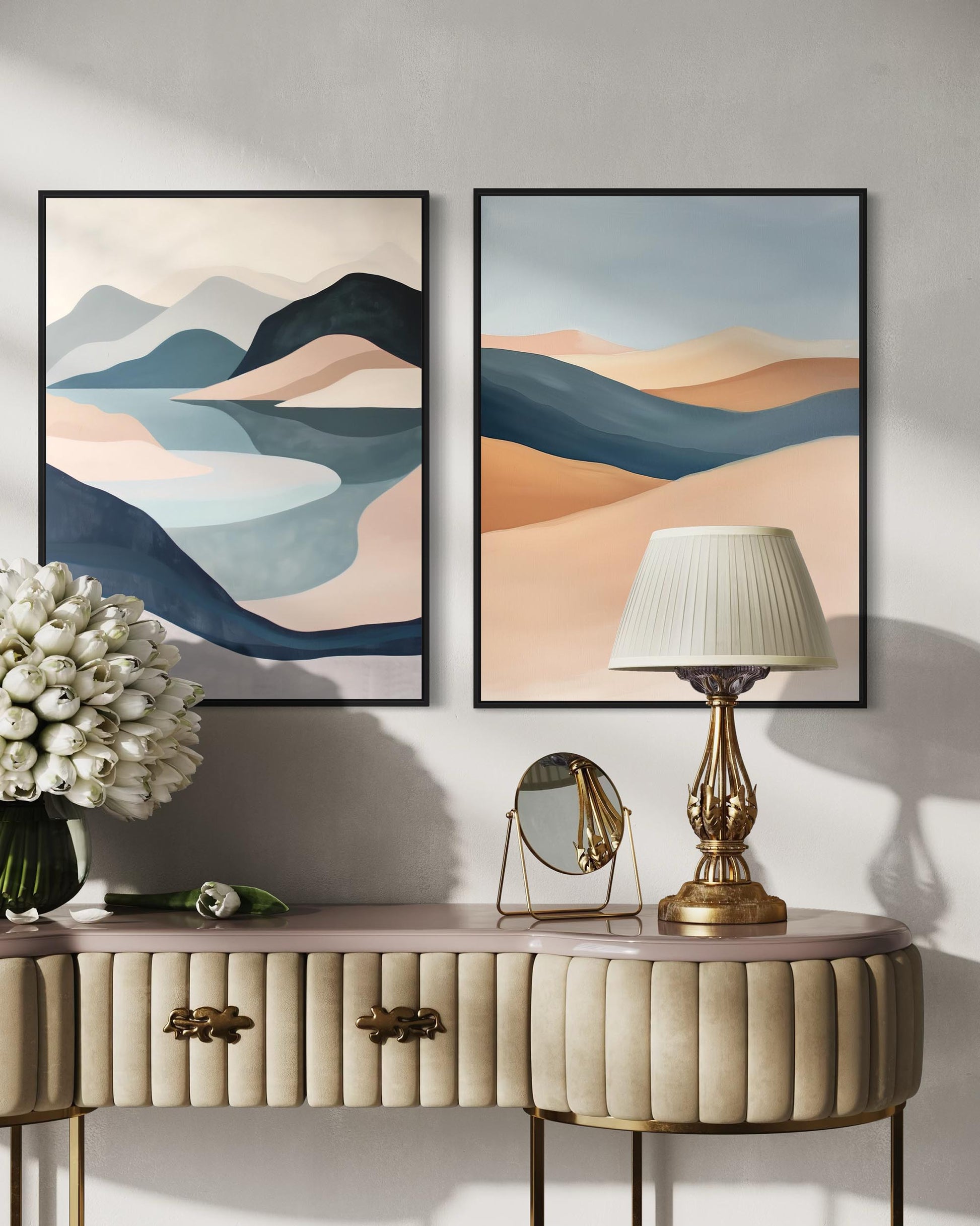 Two abstract landscape paintings on a wall above a console table with decorative items.