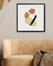 Abstract art piece on a wall above a beige sofa with decorative elements.