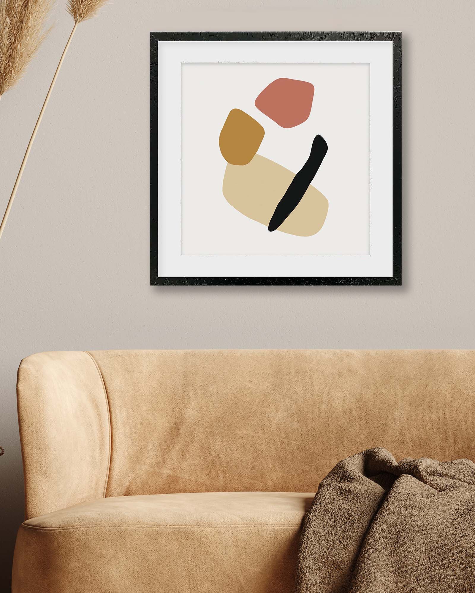 Abstract art piece on a wall above a beige sofa with decorative elements.