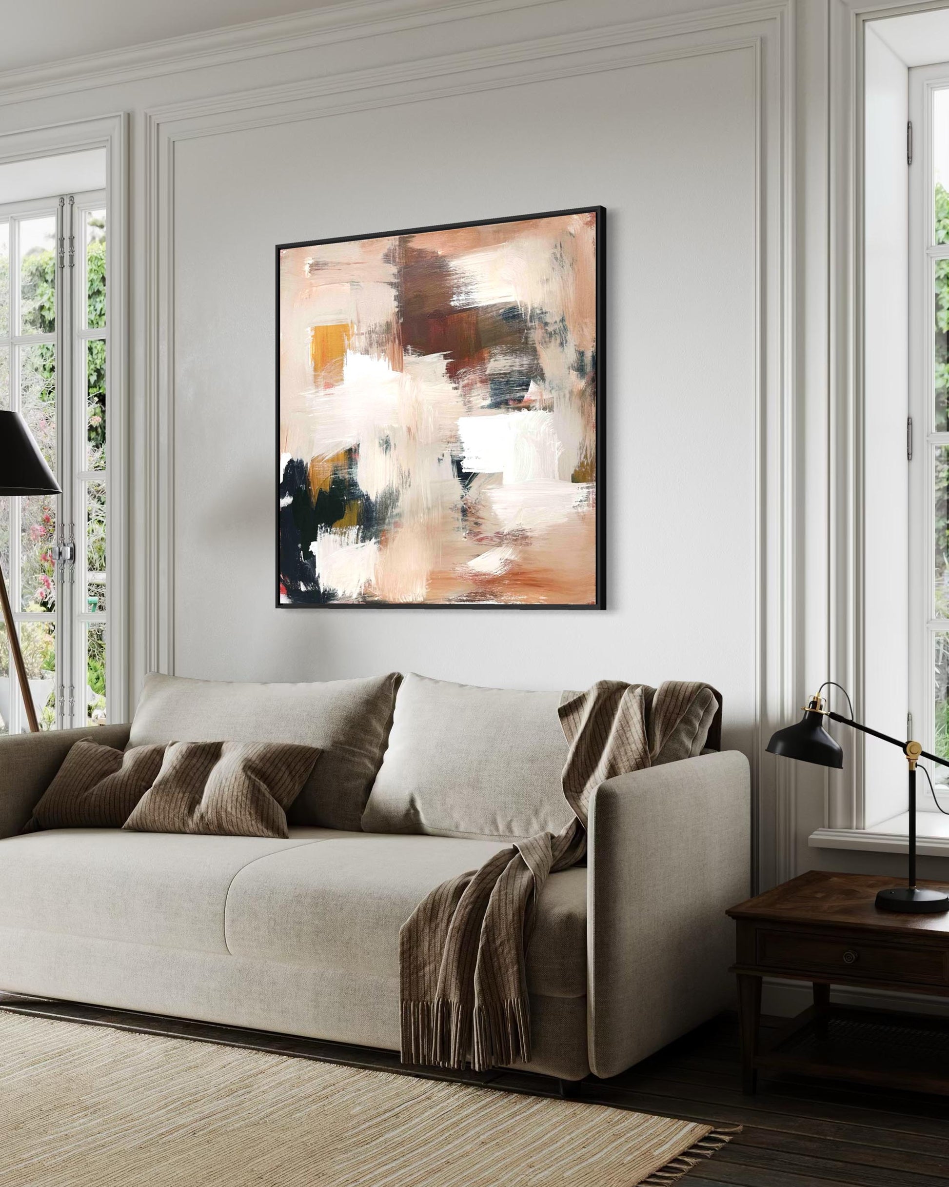 Modern living room with a beige sofa, abstract painting, and side table.