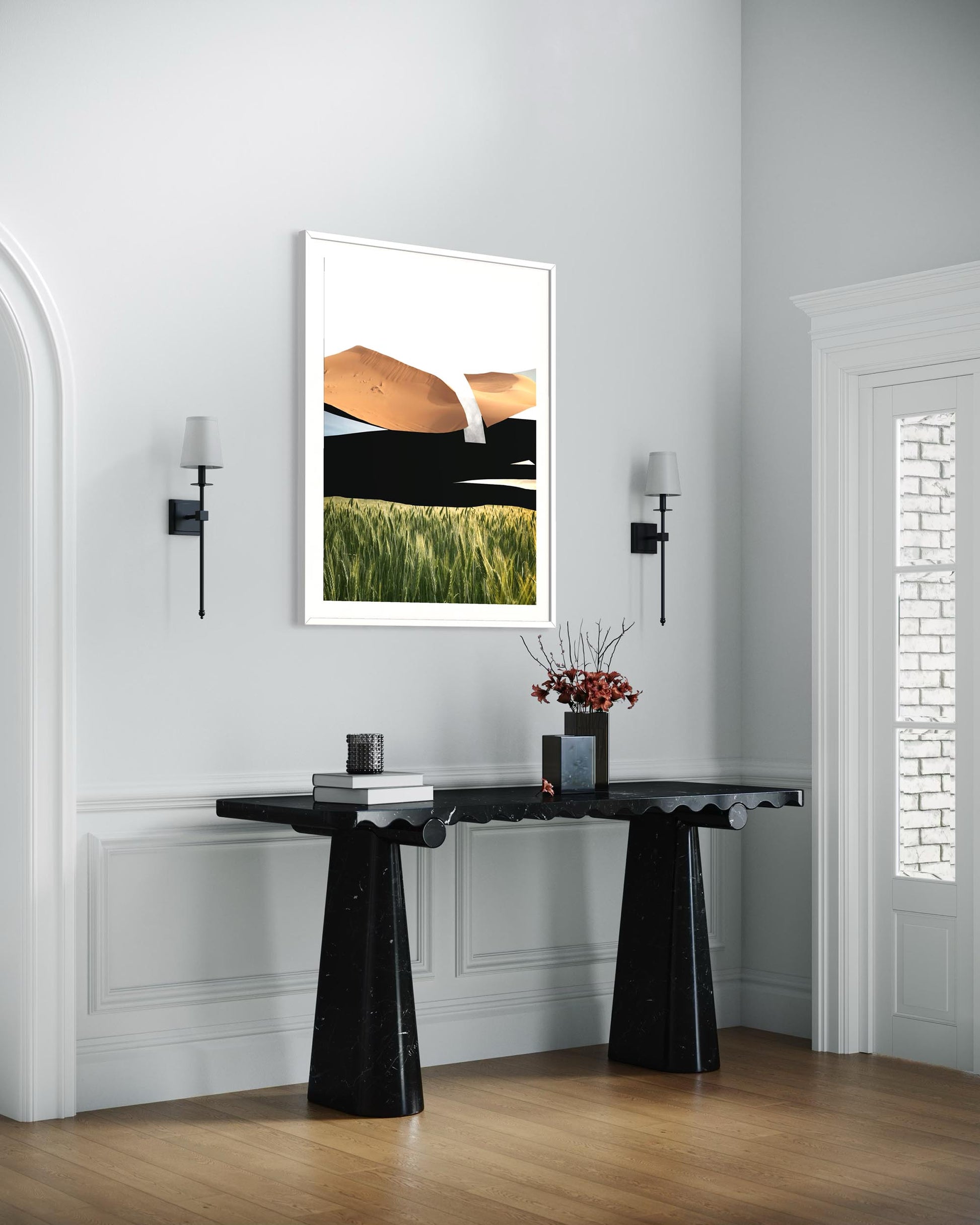 Modern interior with a black console table and framed artwork on a white wall.