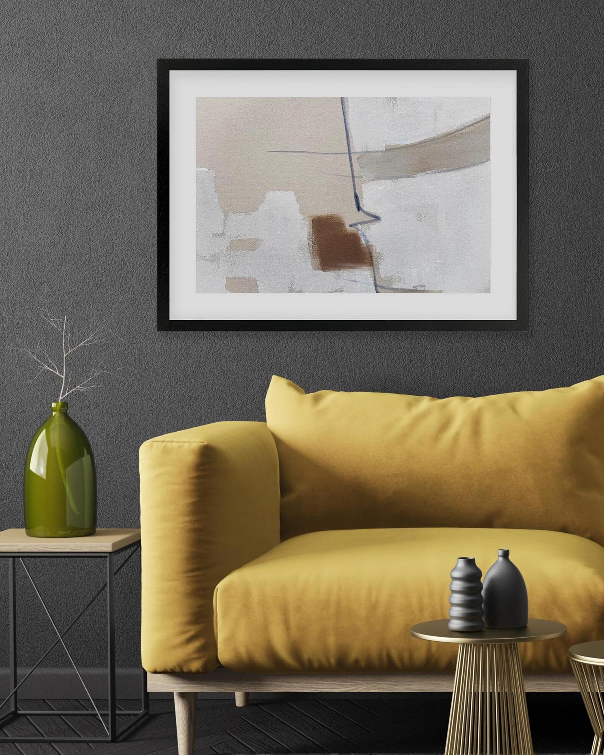 Yellow sofa in a living room with abstract art on the wall