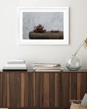 Tea set on a wooden surface with a framed picture above