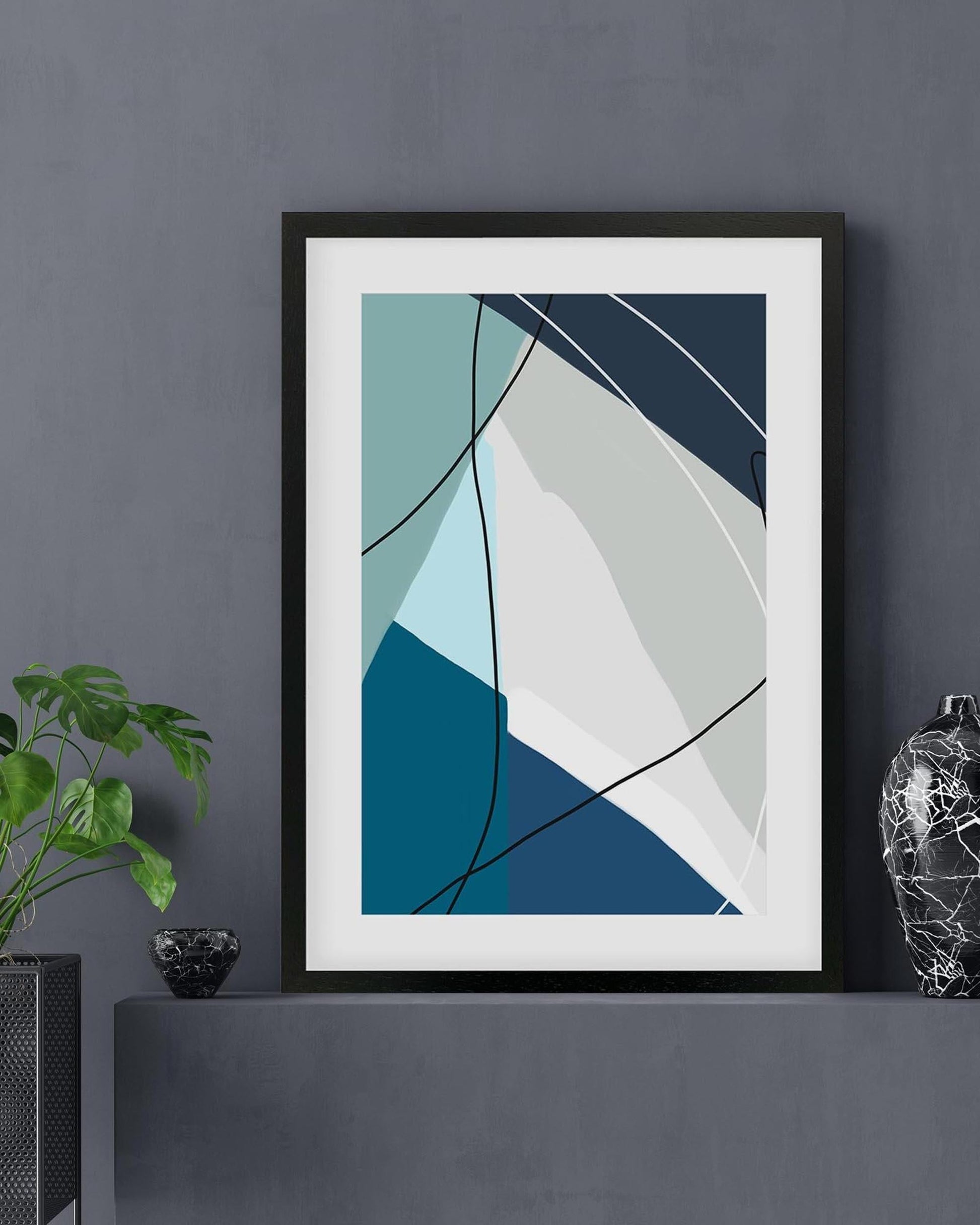 Framed abstract art print on a dark gray wall with decorative elements.