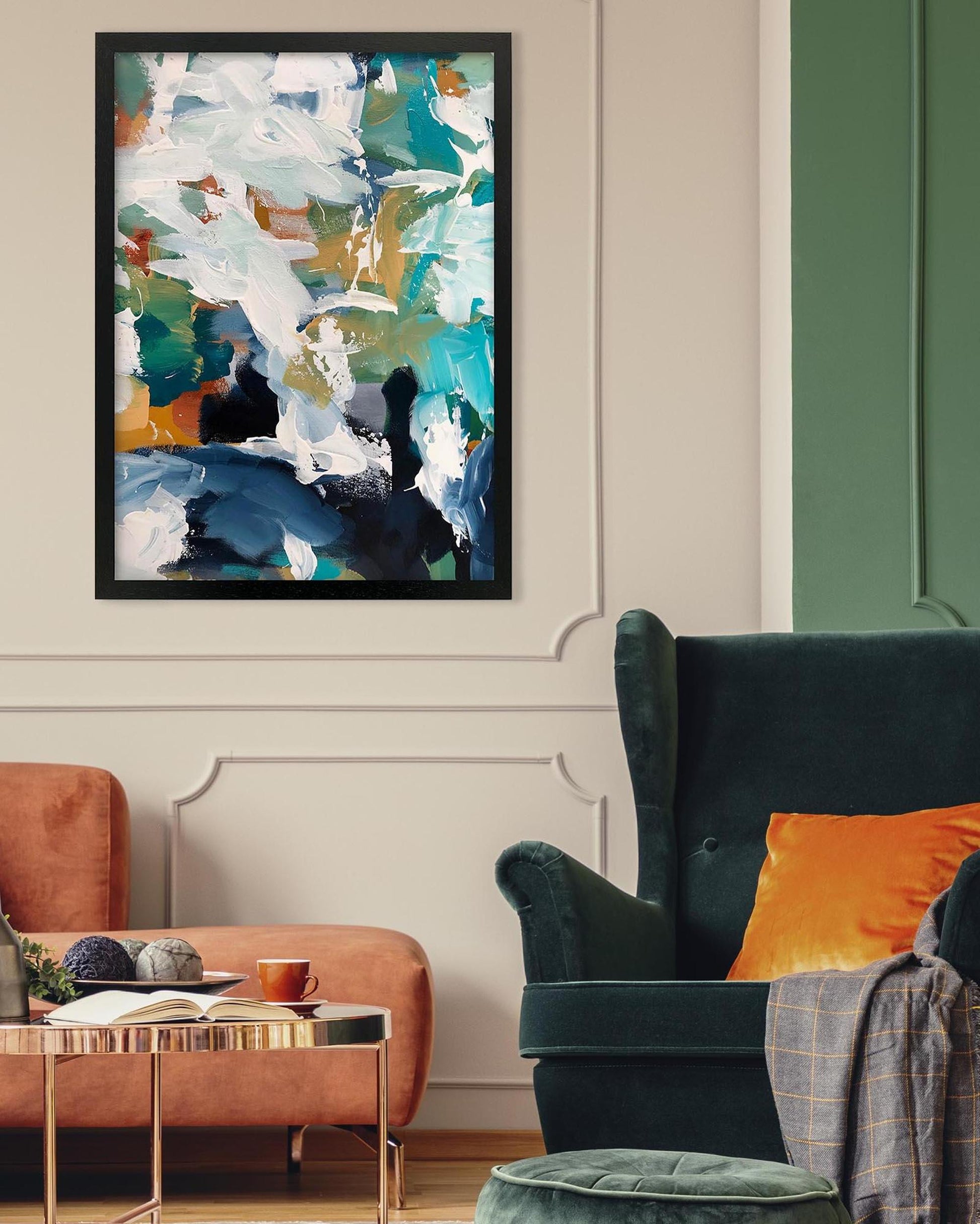 Abstract art print on a wall above a green armchair and orange sofa.
