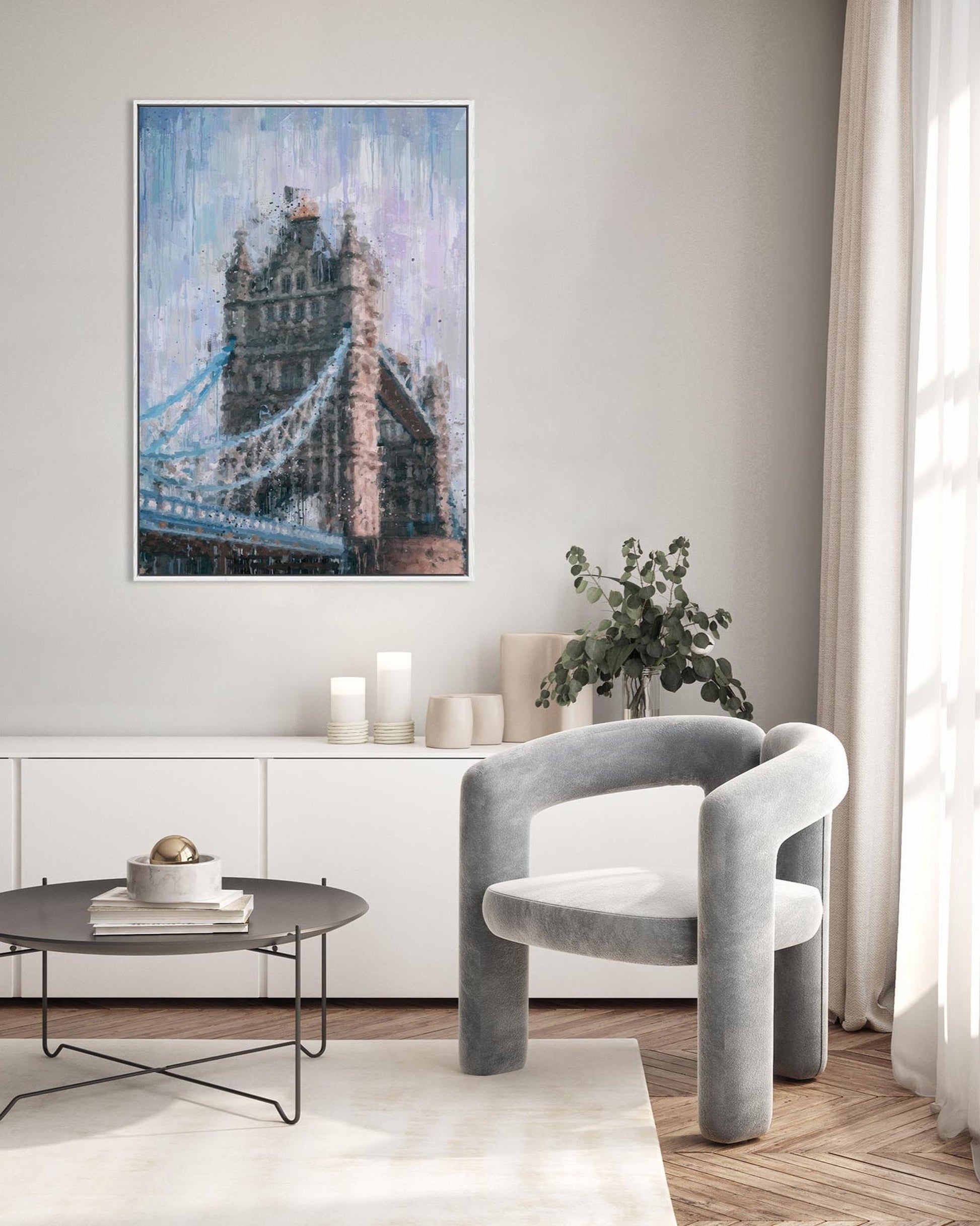 Modern living room with a gray chair, round coffee table, and abstract painting of a bridge.