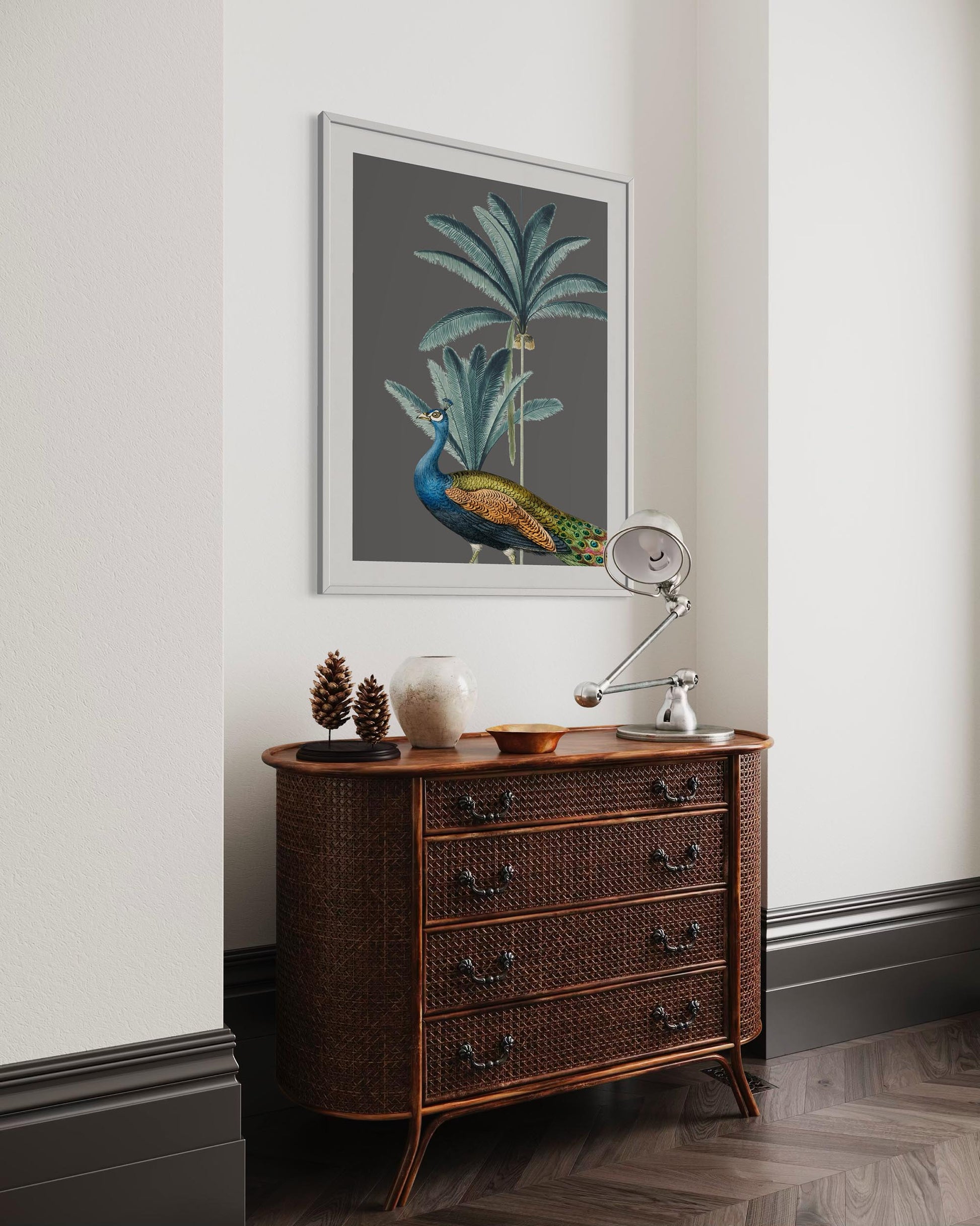 peacock art print framed in a white frame above a sideboard