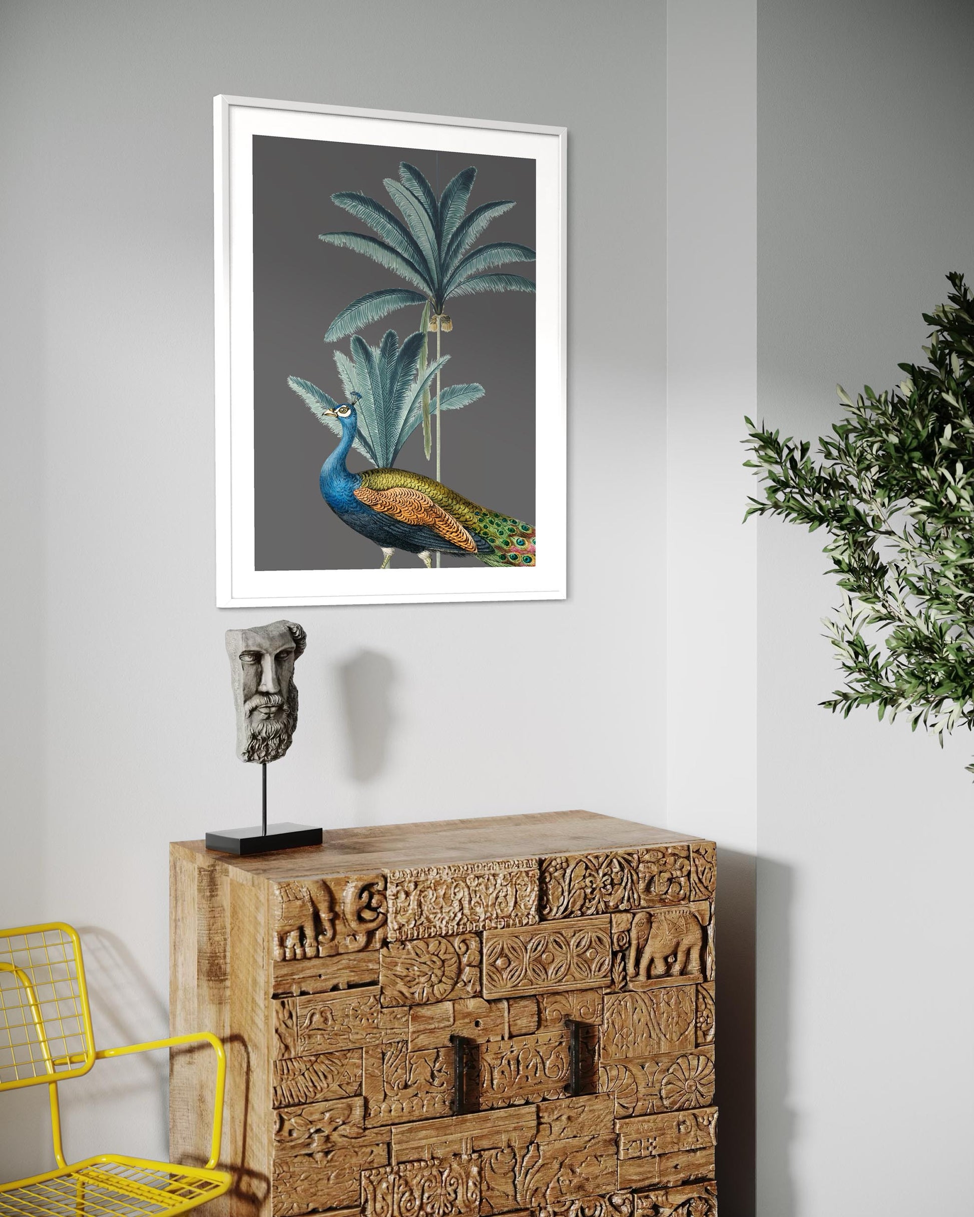 peacock art print in a white frame above a vintage sideboard