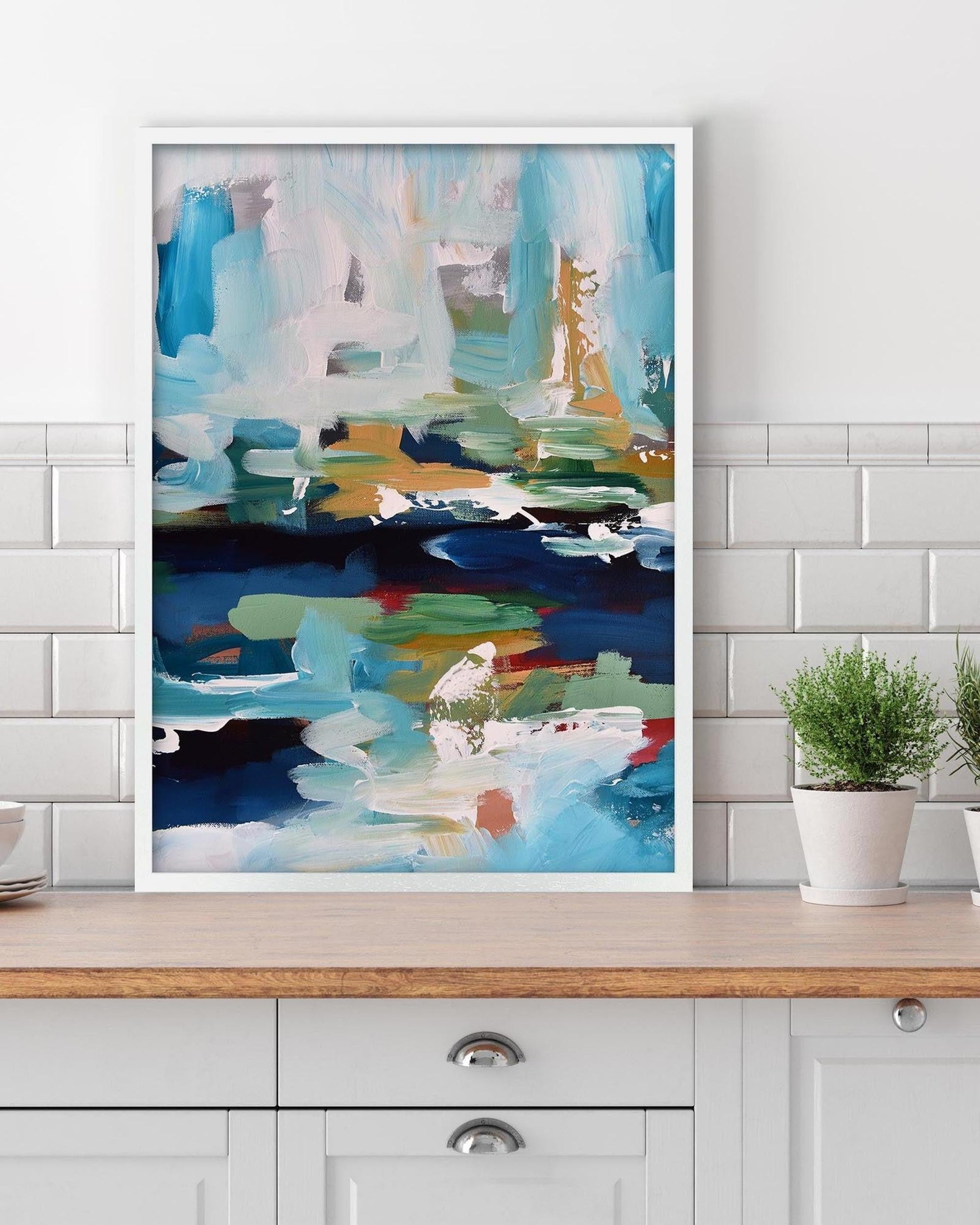 Abstract painting on a wall above a wooden shelf with plants