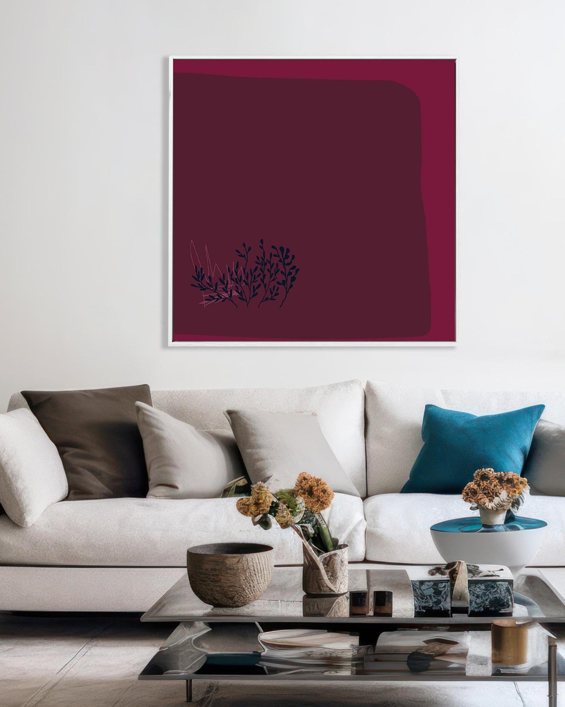 Modern living room with a white sofa, decorative pillows, and a framed abstract art piece on the wall.