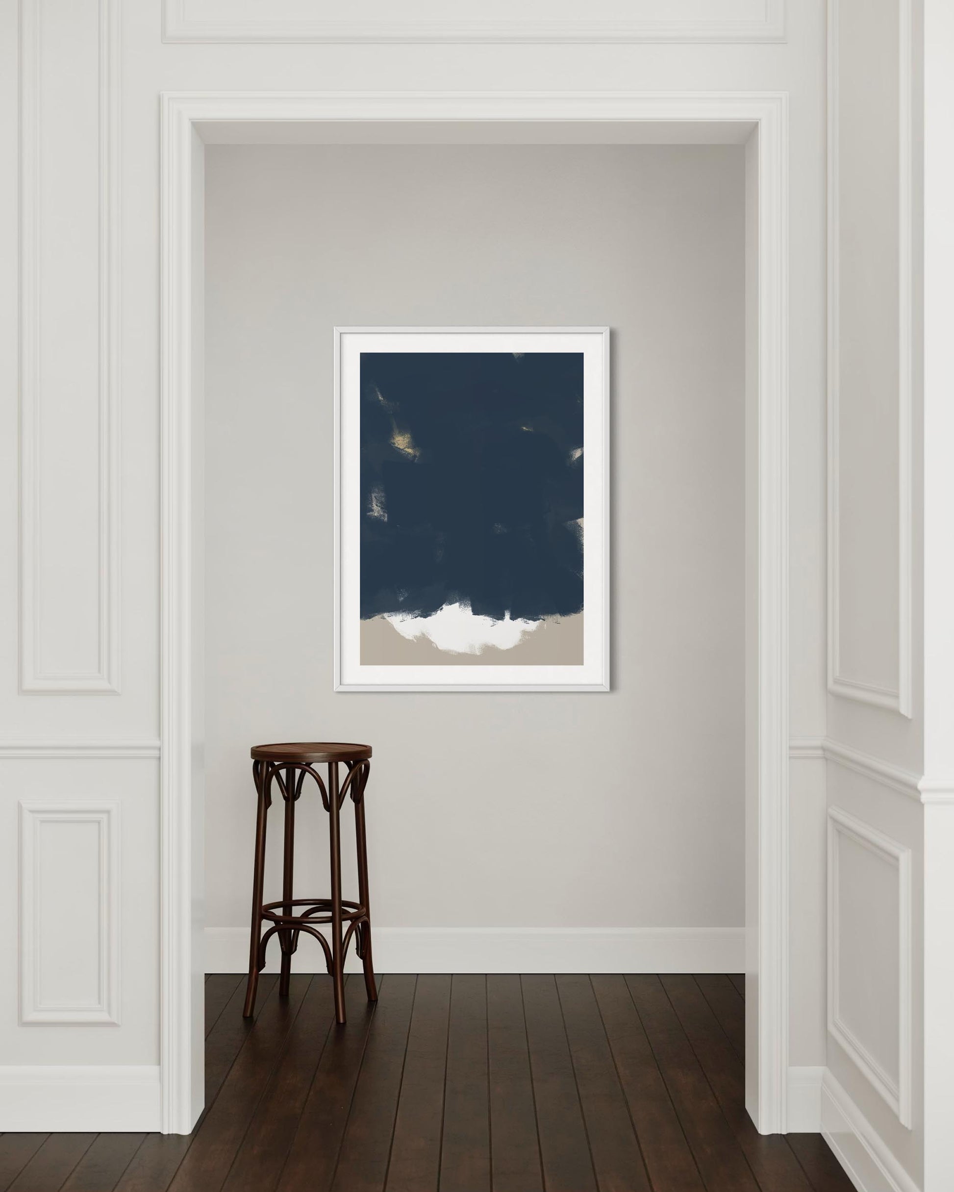 Framed artwork on a wall with a wooden stool below