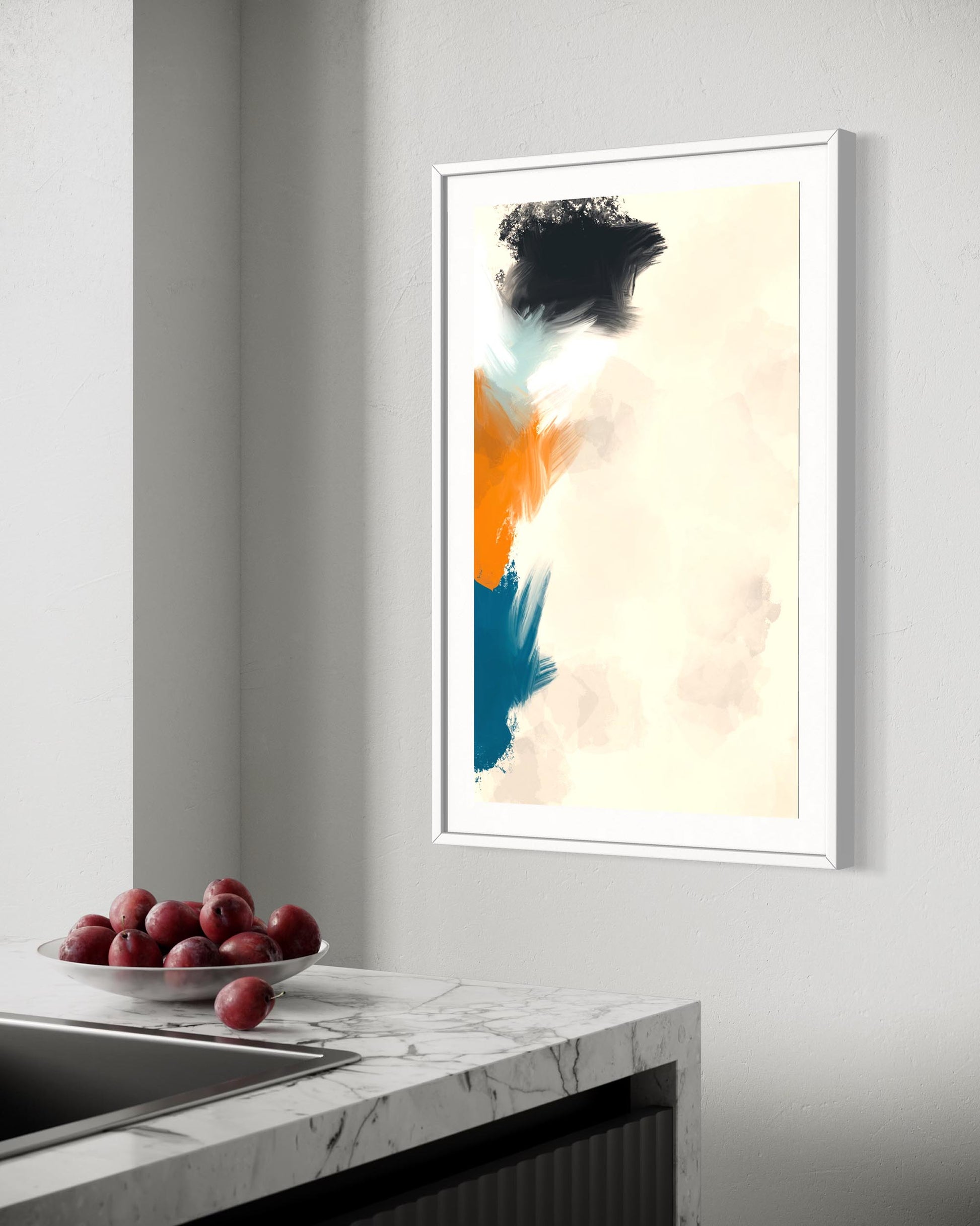 Framed abstract art on a wall above a kitchen counter with fruit.