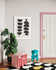 Modern interior with abstract art, pink stools, and a polka dot rug.