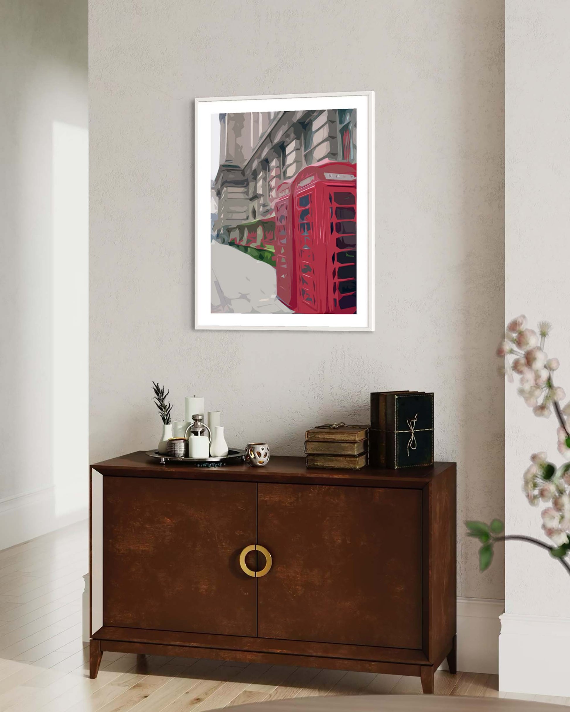 Framed artwork of a red telephone box on a wall above a wooden cabinet.