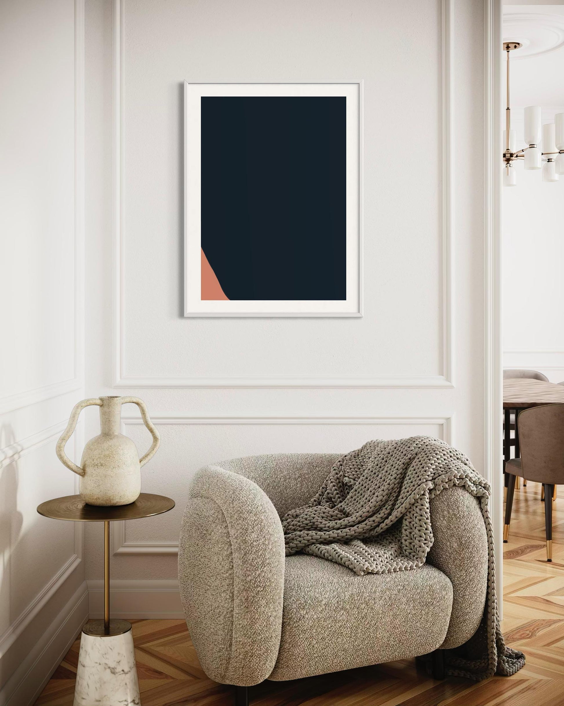 Modern interior with a beige armchair, side table, and abstract art on the wall.