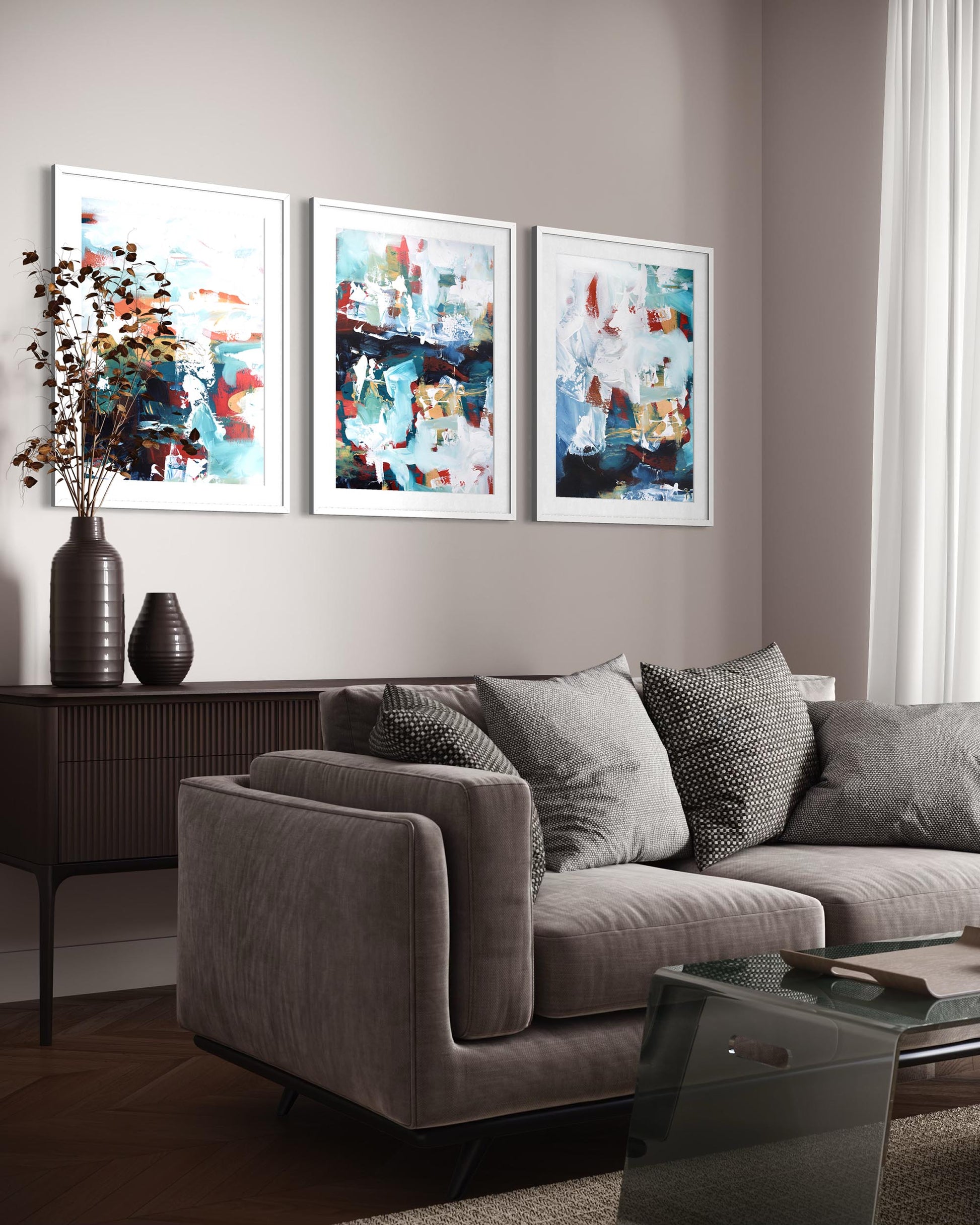 Gray sofa with decorative pillows in a living room with abstract art on the wall.