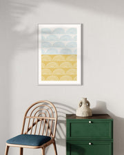 Framed abstract art print on a wall with a chair and green cabinet below.